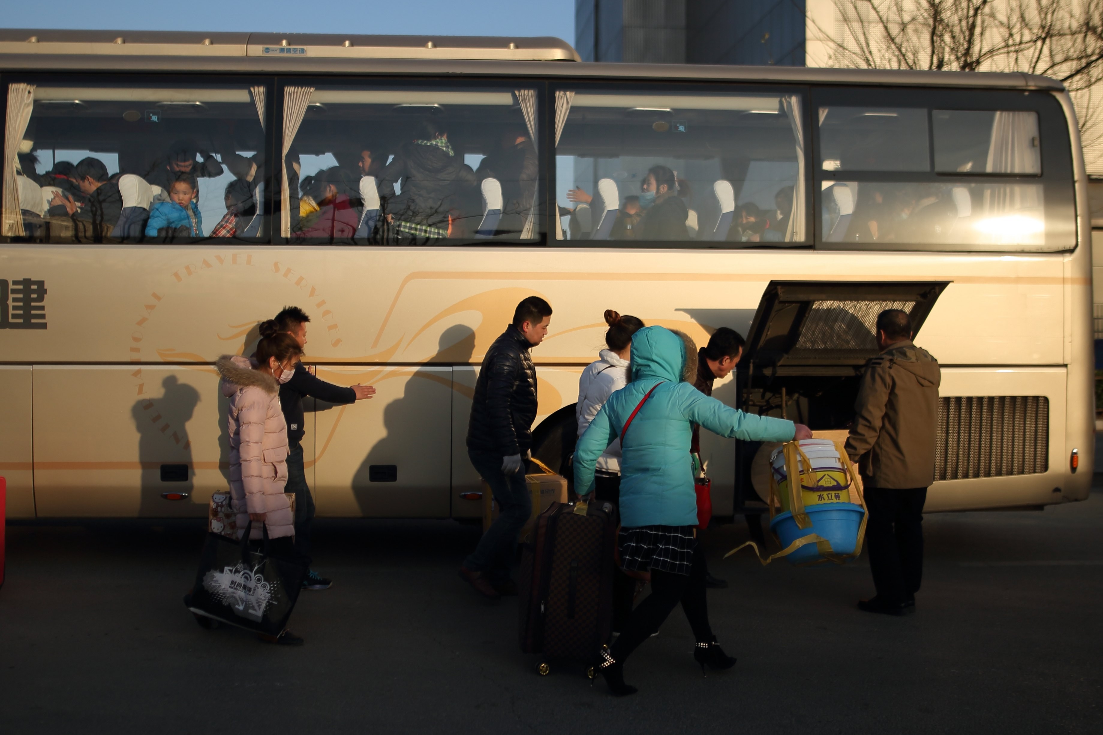 Migrant workers get on a long-distance bus to leave Beijing on November 24, after their factory was closed by the authorities in a crackdown on migrant worker communities. They will move to Changshu in Zhejiang, where the factory will be relocated. Photo: EPA-EFE