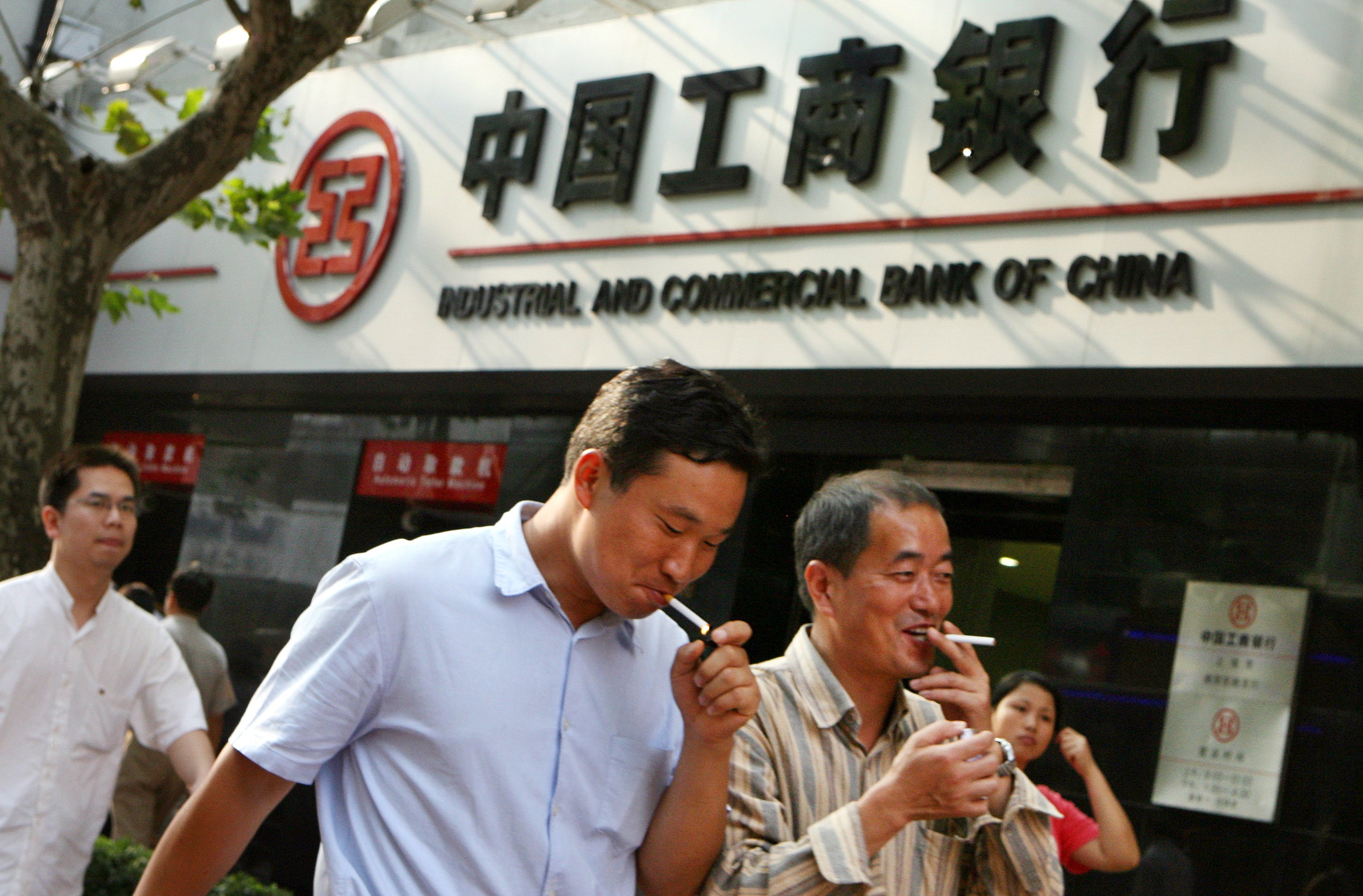 A group of Chinese men walks past a branch of the Industrial and Commercial Bank of China in Shanghai. Photo: AFP