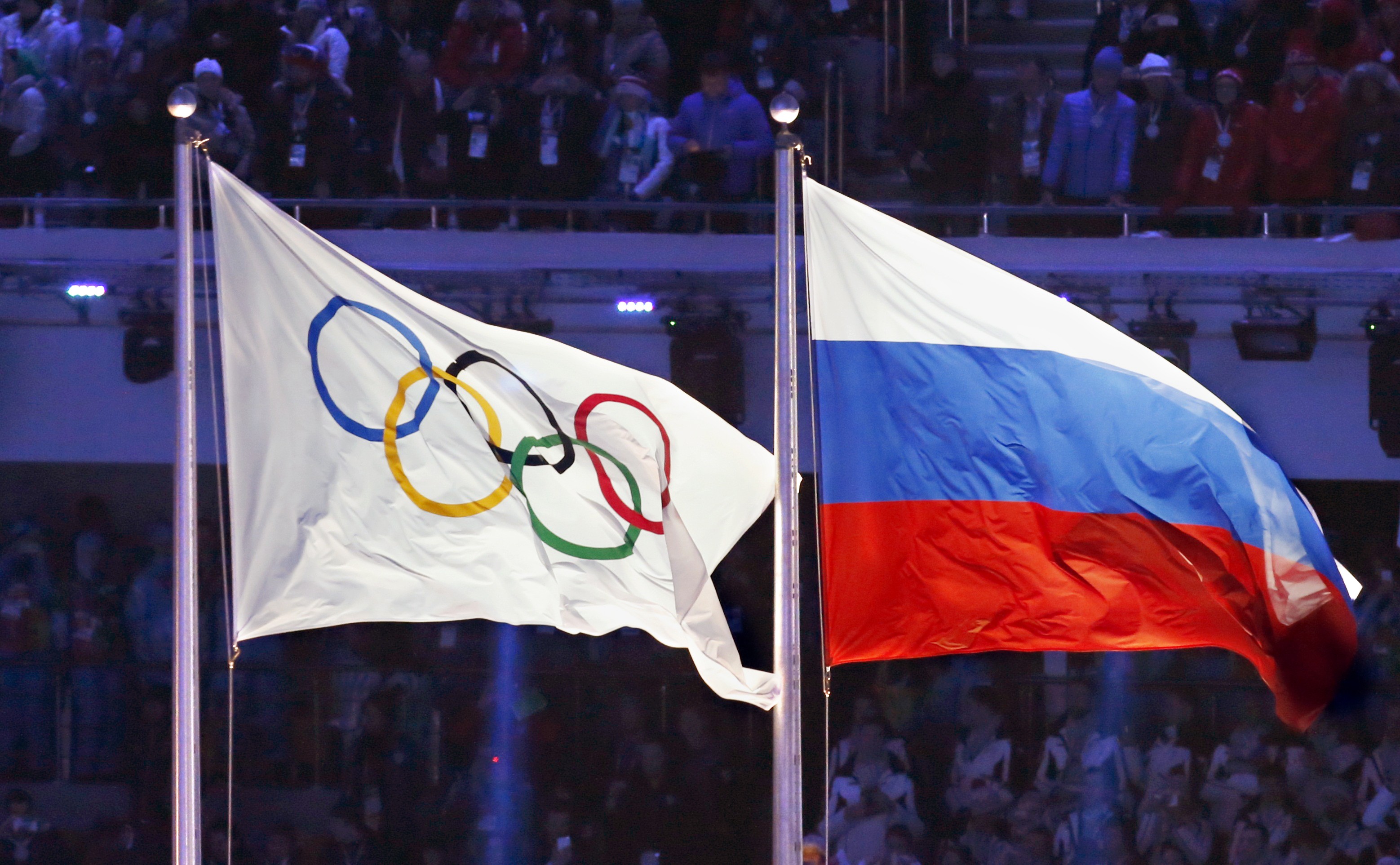 The Olympic flag flying alongside the Russian flag at the 2014 Winter Olympics opening ceremony in Sochi. Photo: Kyodo