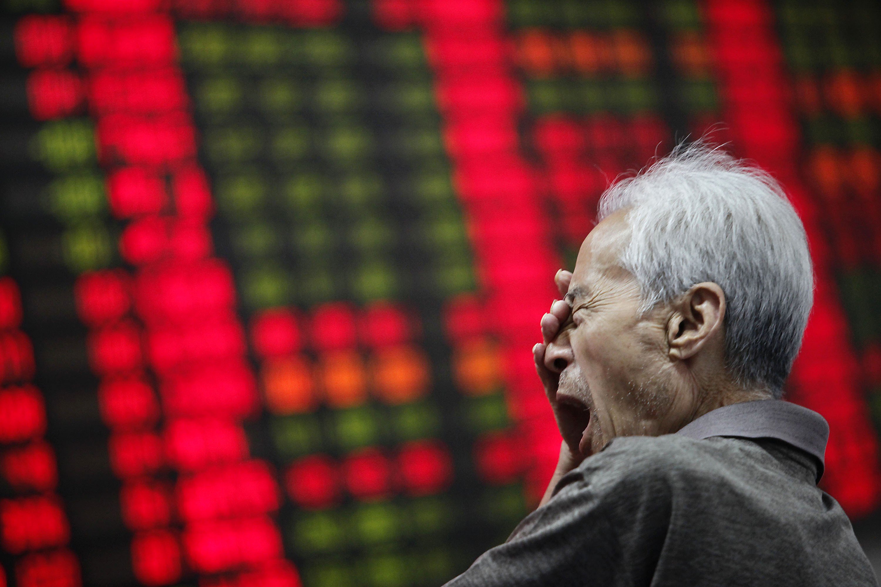 An investor yawns as he looks at a stock price monitor at a private securities company in Shanghai.Photo: AP
