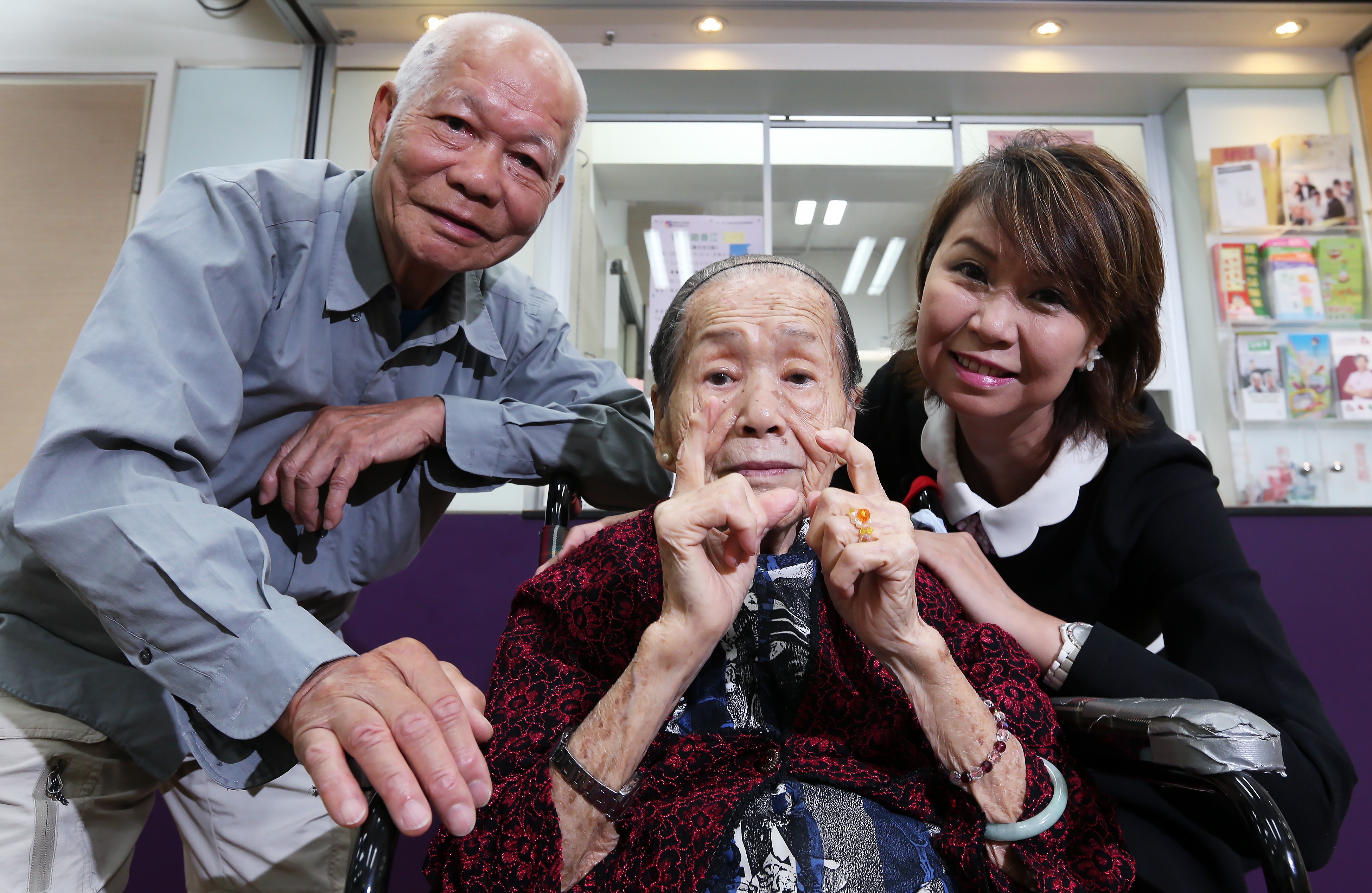 Two senior citizens pose for a picture with social worker Maggie Man at the ICFG Lung Hang Church Elderly Centre in Sha Tin in 2015. The government’s lump-sum grant funding system is designed to encourage welfare agencies to build community partnerships to address social problems effectively. Photo: David Wong