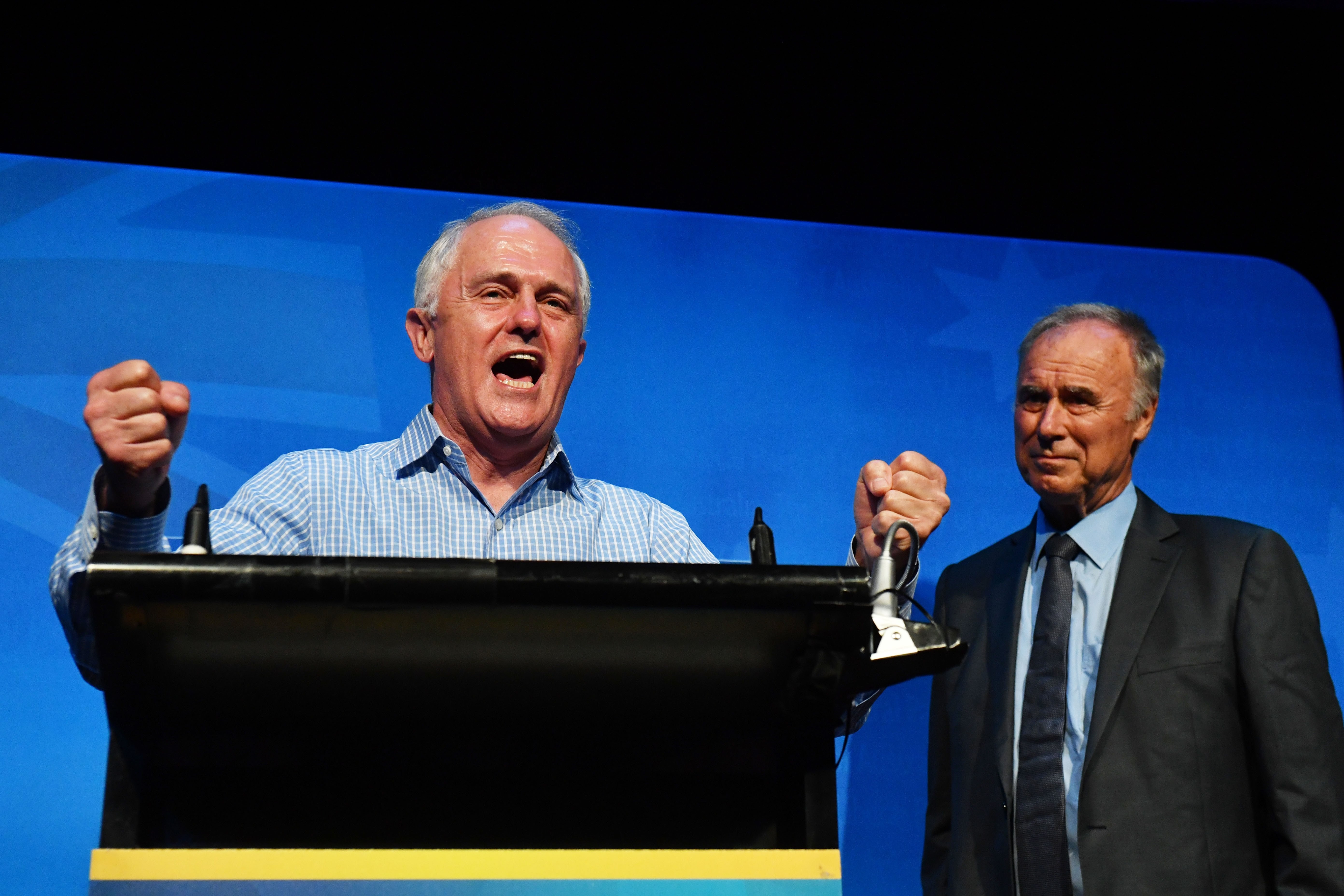New Liberal member for Bennelong John Alexander watches Australian Prime Minister Malcolm Turnbull celebrate the by-election victory at the West Ryde Leagues Club. Photo: EPA