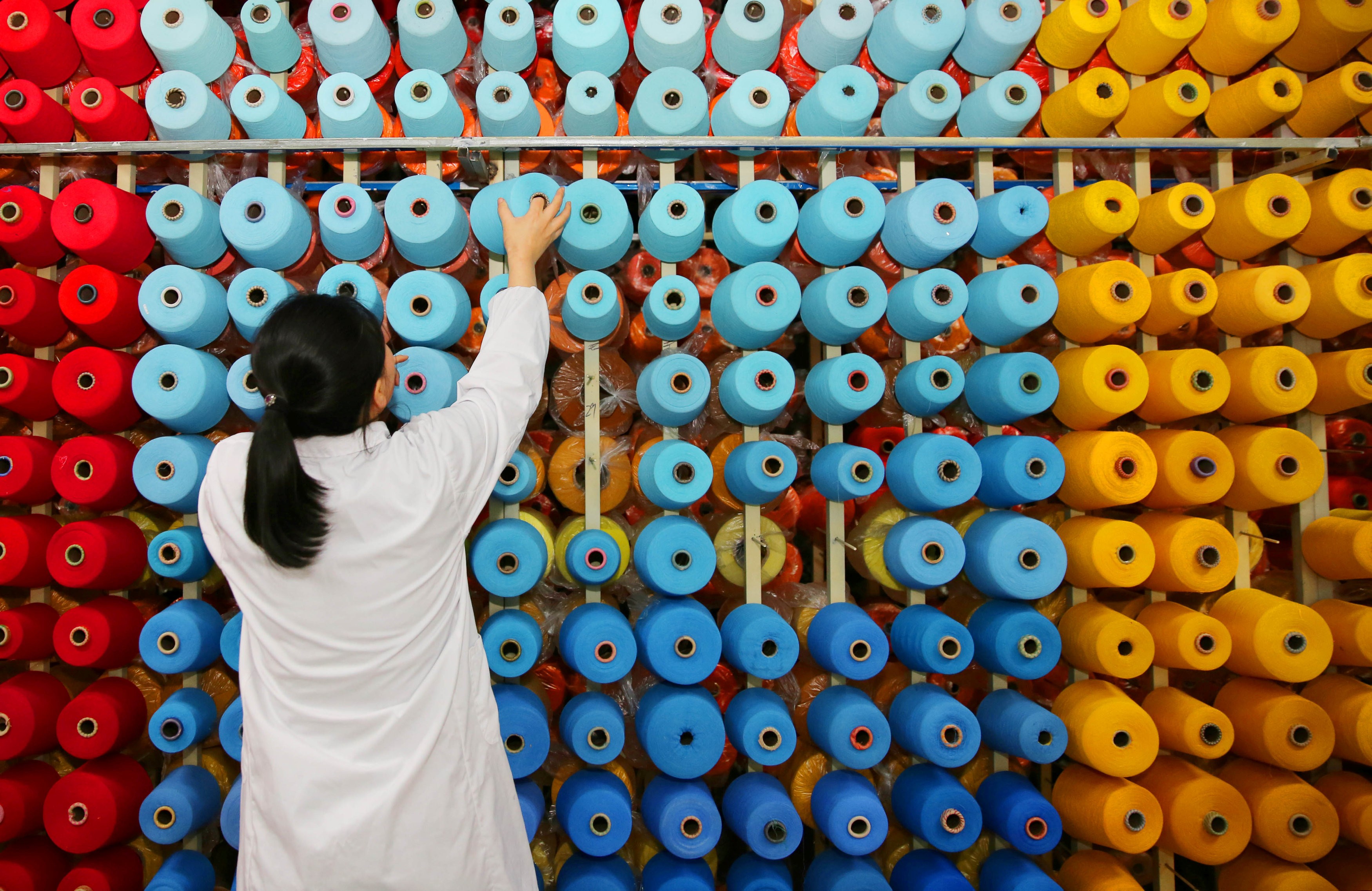 An employee arranges bobbins at a textile plant in Haian county in Jiangsu province on November 28, 2017. Photo: Reuters