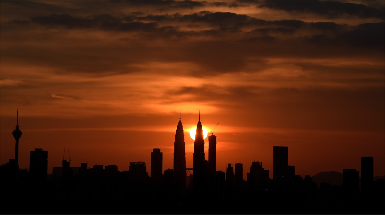 Malaysia's landmark Petronas Twin towers are silhoutted as the sun sets over the Kuala Lumpur skyline. Photo: AFP/MANAN VATSYAYANA