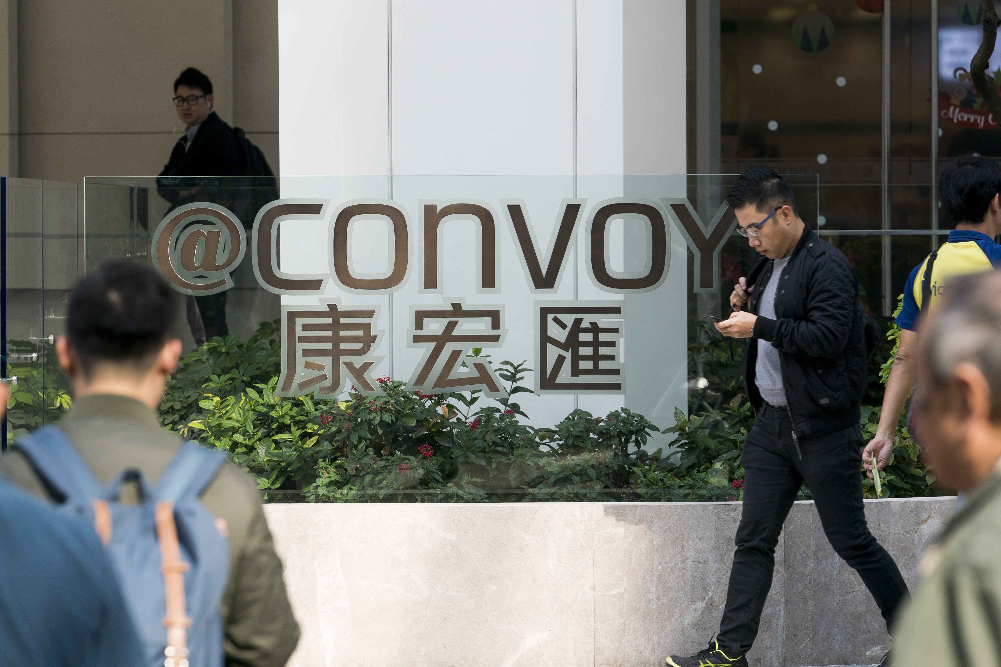 Pedestrians walk past the "@Convoy" building, which houses the headquarters of Convoy Global Holdings. Convoy has confirmed that three executive directors were arrested by the anti-corruption agency, including Chairman Wong Lee Man, according to a filing last week. Photo: Bloomberg
