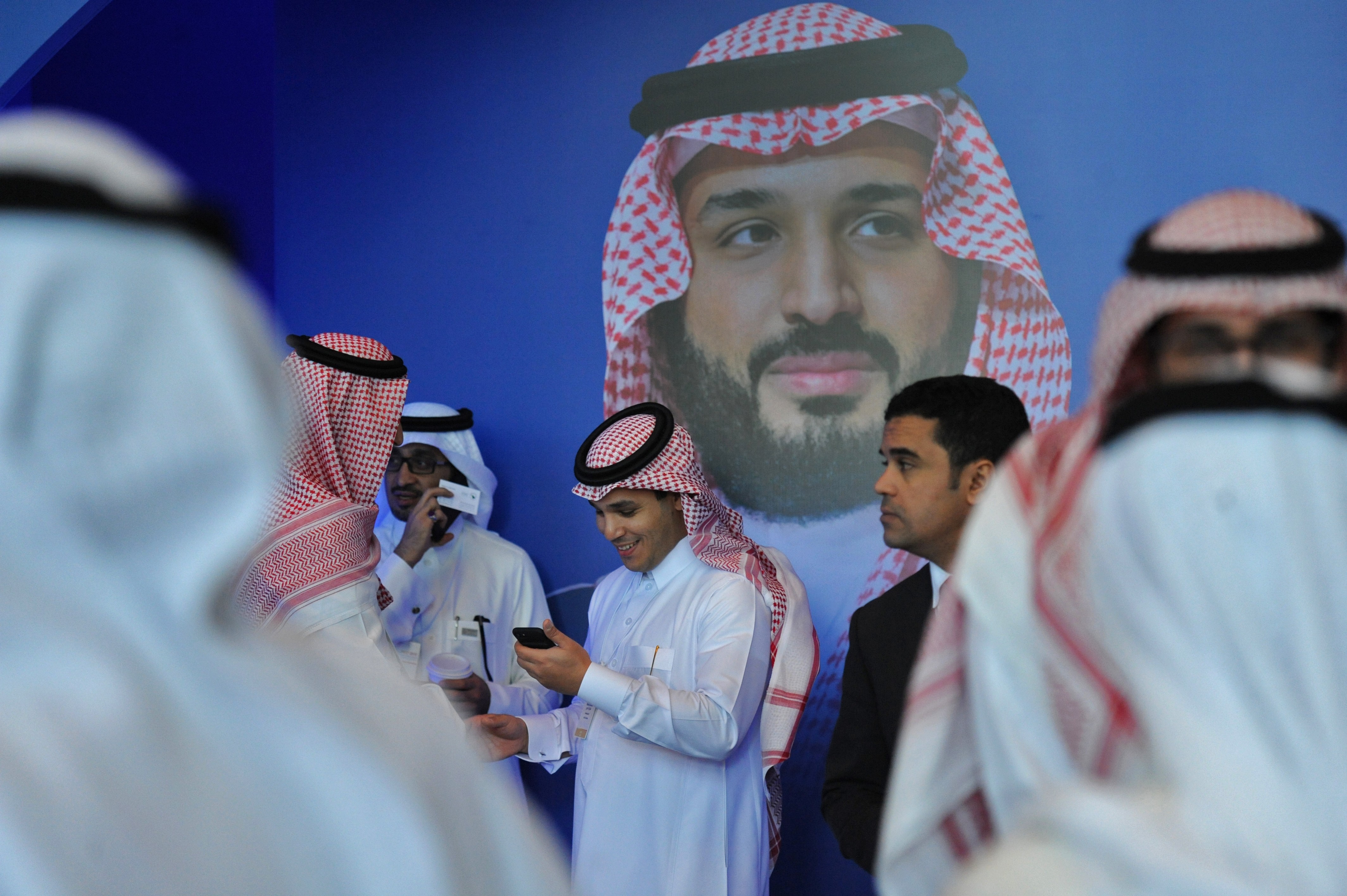 Saudi men chat in front of a poster of Saudi Crown Prince Mohammed bin Salman during the MiSK Global Forum held under the slogan Meeting the Challenge of Change in Riyadh, in November. Photo: AFP
