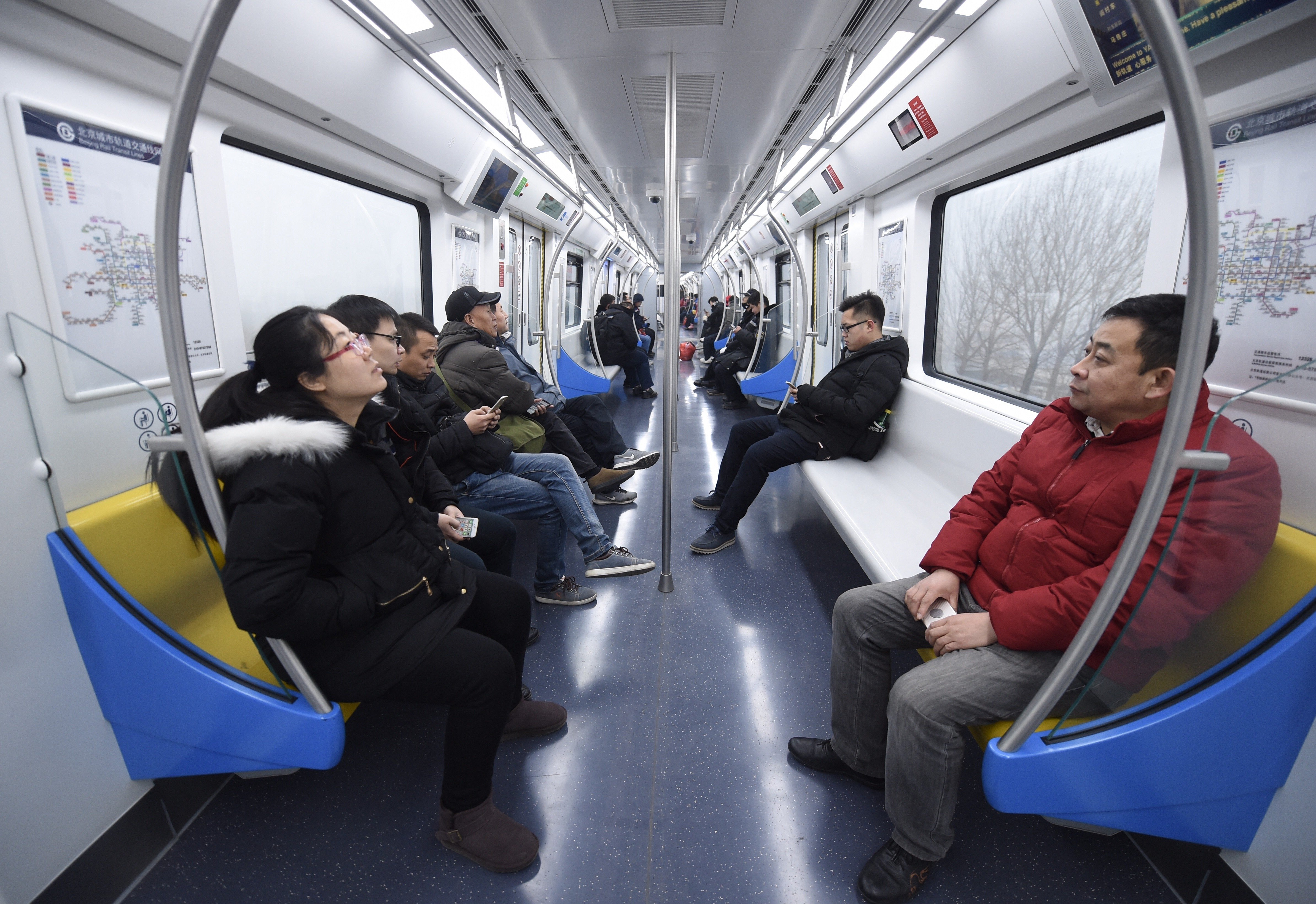 Students play online games inside a subway train in Beijing