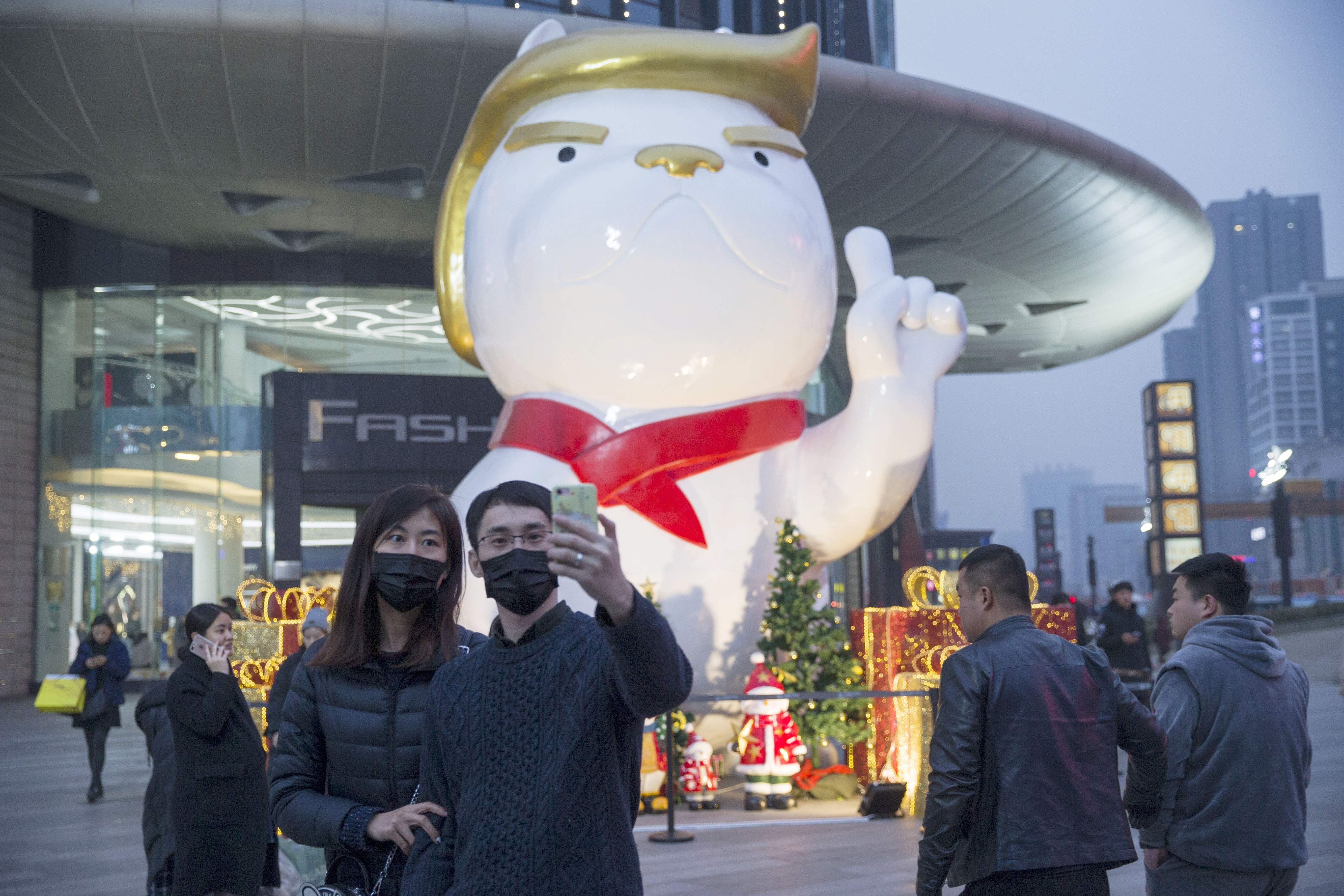 A statue with a likeness to US President Donald Trump heralds the Year of the Dog outside a shopping centre in northern China. There are signs the Trump administration will take some sort of tough trade action against China. Photo: AFP
