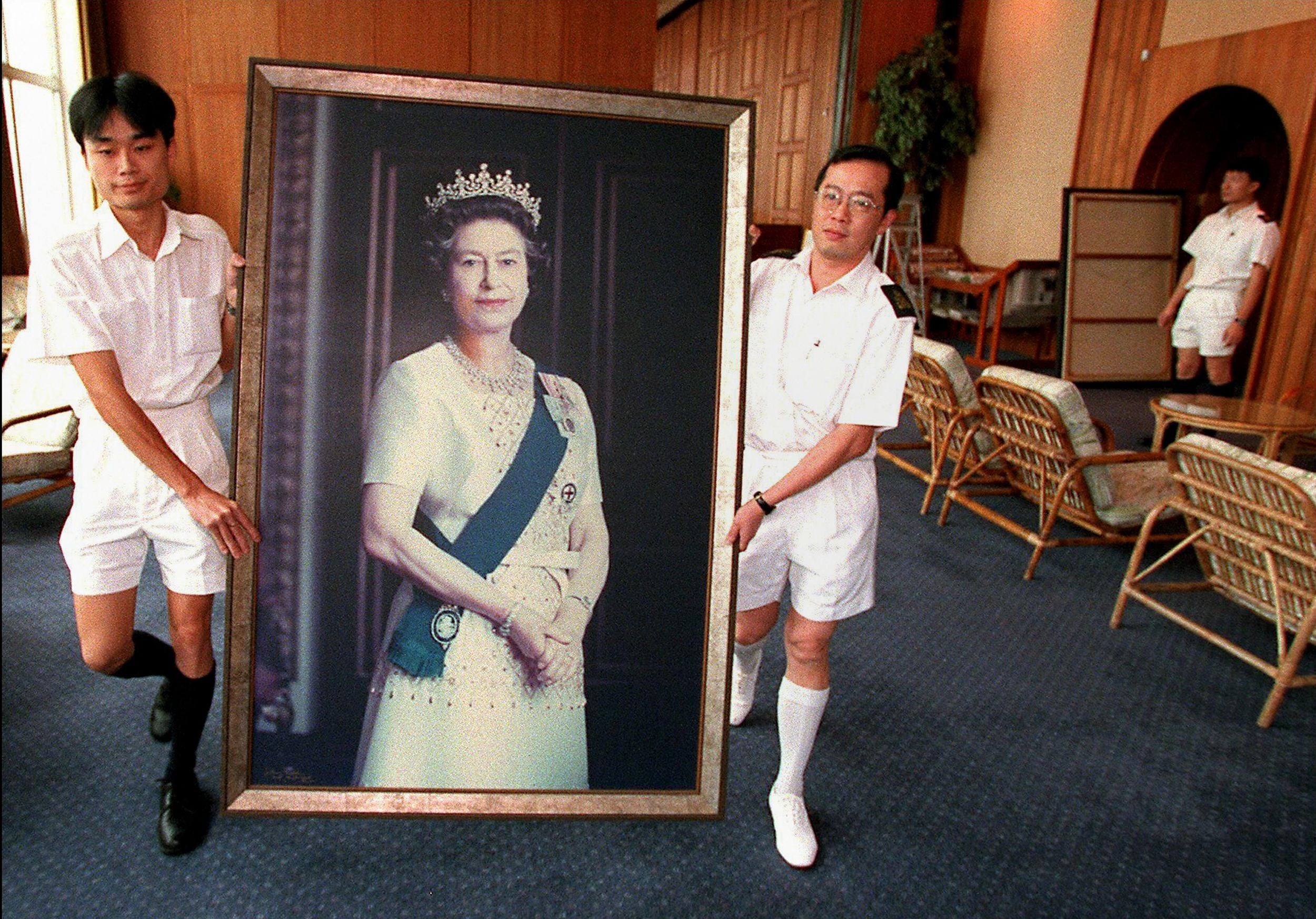 Two sailors carrying a portrait of Queen Elizabeth through the HMS Tamar ahead of the end of British rule in Hong Kong. Photo: AFP