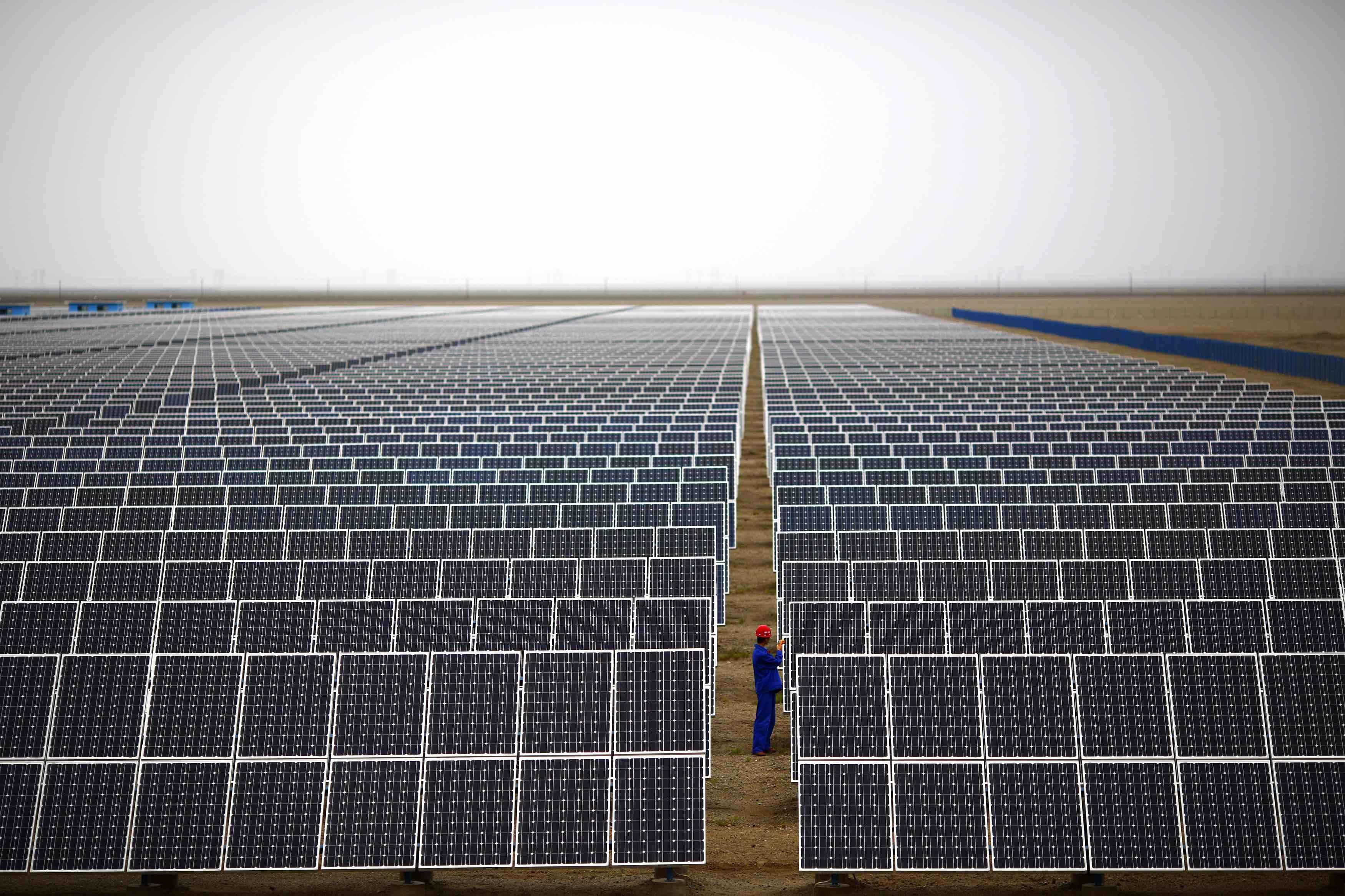A worker inspects panels at a solar farm in Dunhuang, Gansu province, in 2013. Environmental targets have been incorporated into the country’s economic planning since 2006. Photo: Reuters