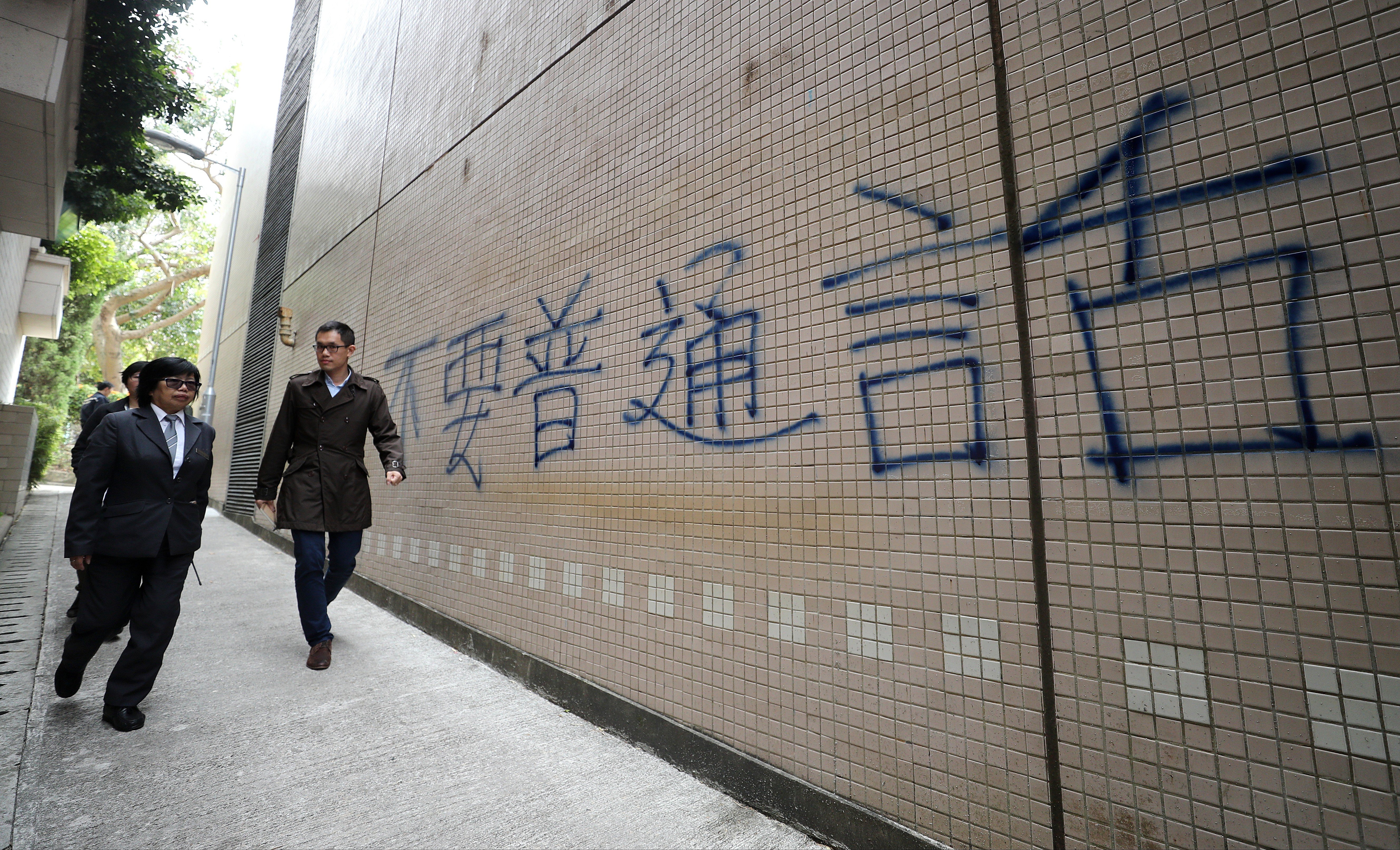 Police follows up on the "No Putonghua" graffiti near the wall of the Baptist University Sports Centre in Kowloon Tong. Photo: Winson Wong