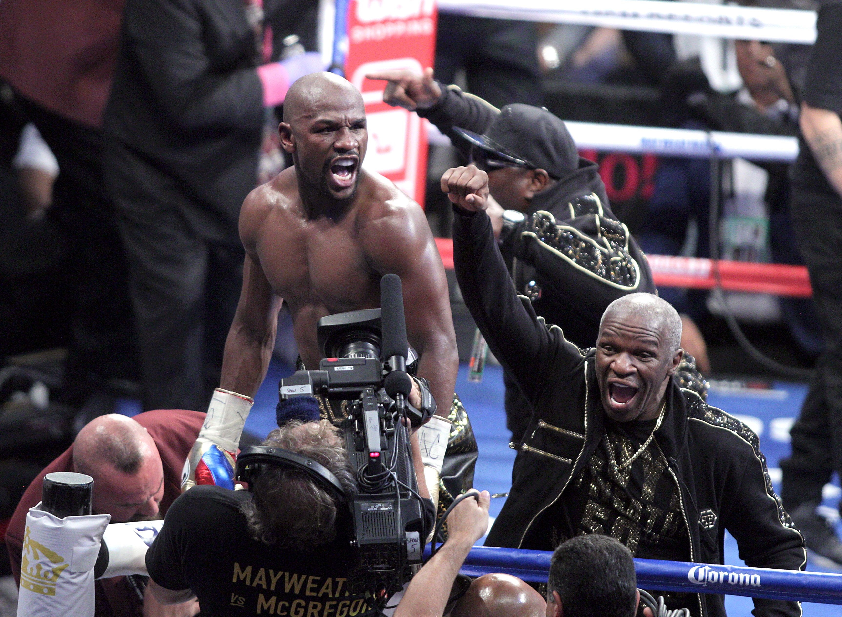 Floyd Mayweather Jnr and his father celebrate victory over mixed martial arts star Conor McGregor. Photo: AFP