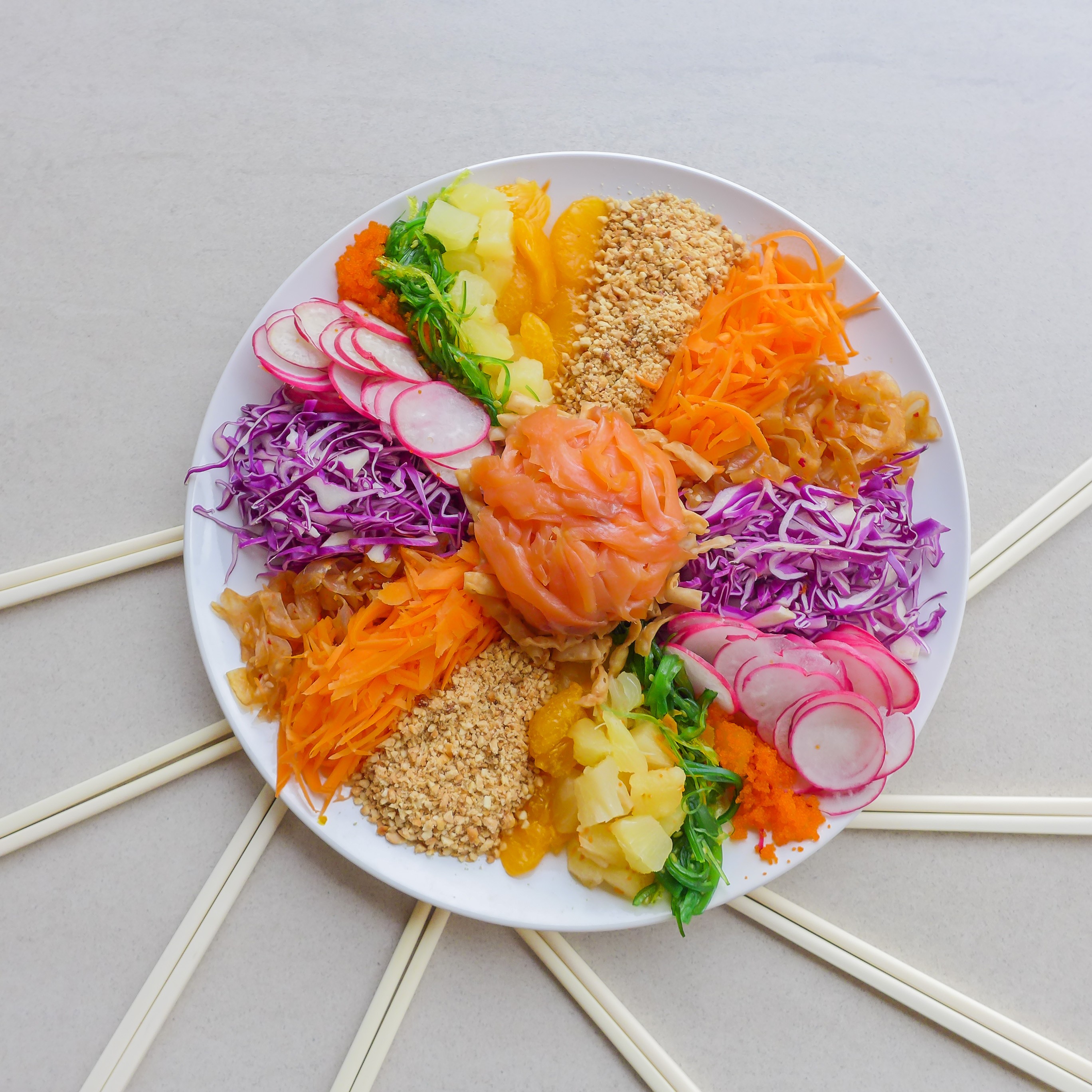 The festive tradition involving raw fish and the dramatic tossing of ingredients can be traced back to Singapore and its “Four Heavenly Kings” of the 1960s