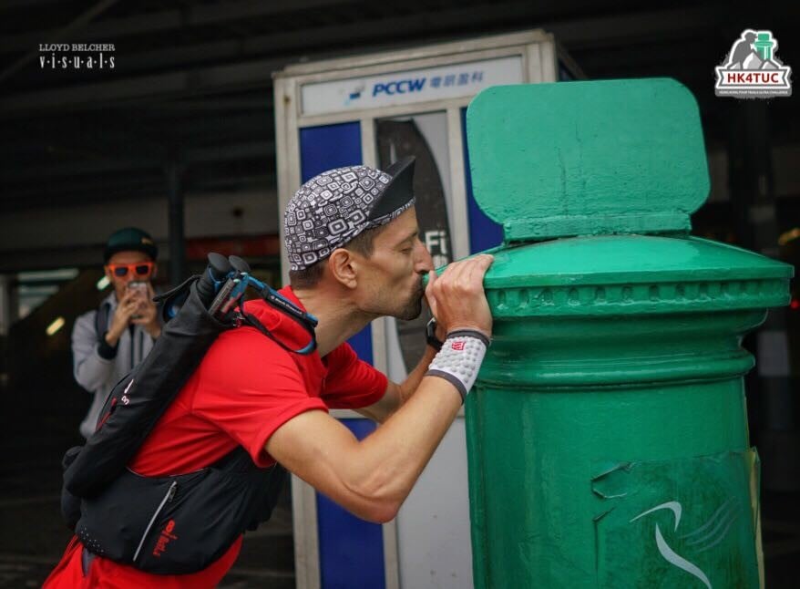Salomon Wettstein kisses the postbox in Mui Wo after becoming the first ‘finisher’ in this year’s Four Trails Ultra Challenge. Photos: Lloyd Belcher Visuals