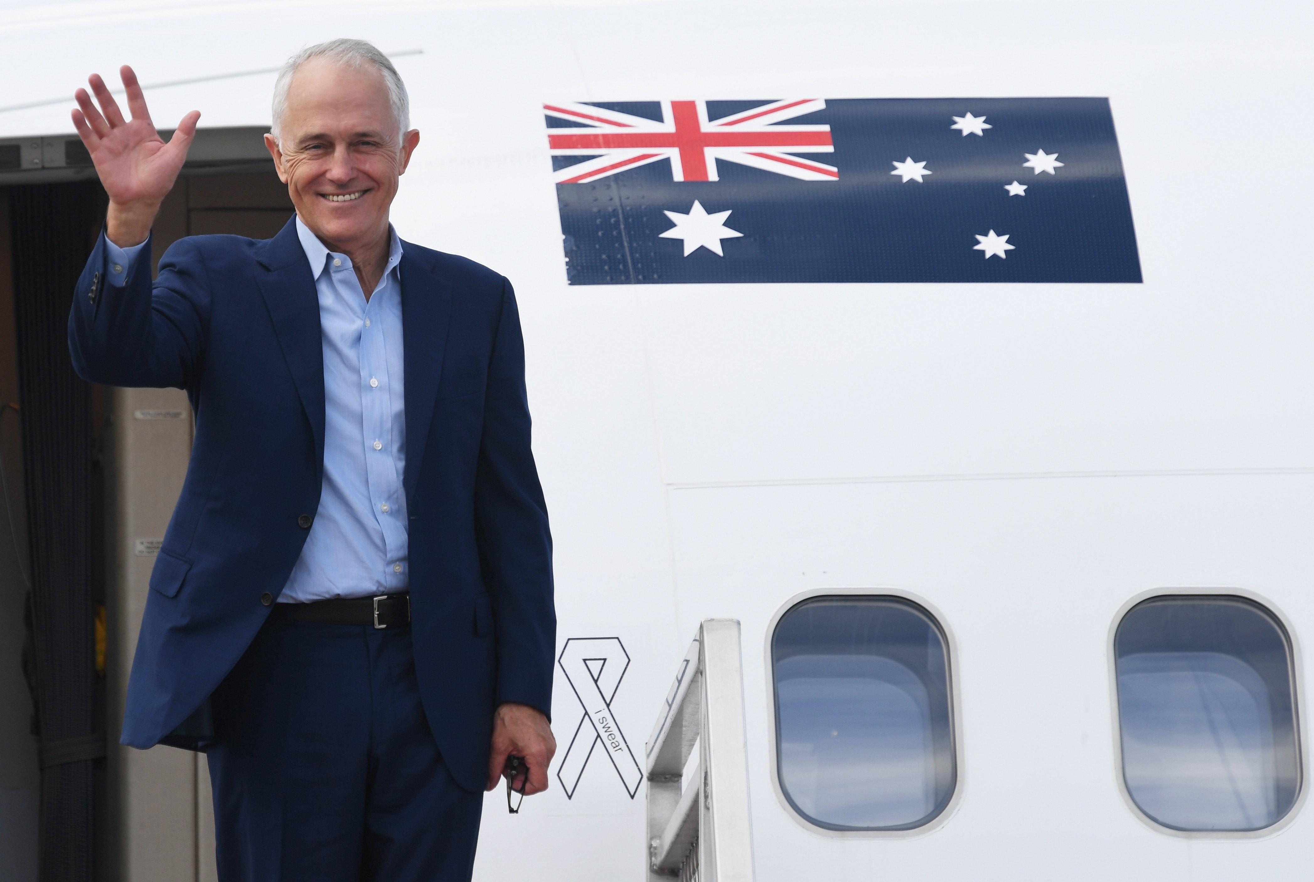 Australian Prime Minister Malcolm Turnbull waves as he boards a plane in Sydney bound for the US, where he will meet President Donald Trump. Photo: EPA