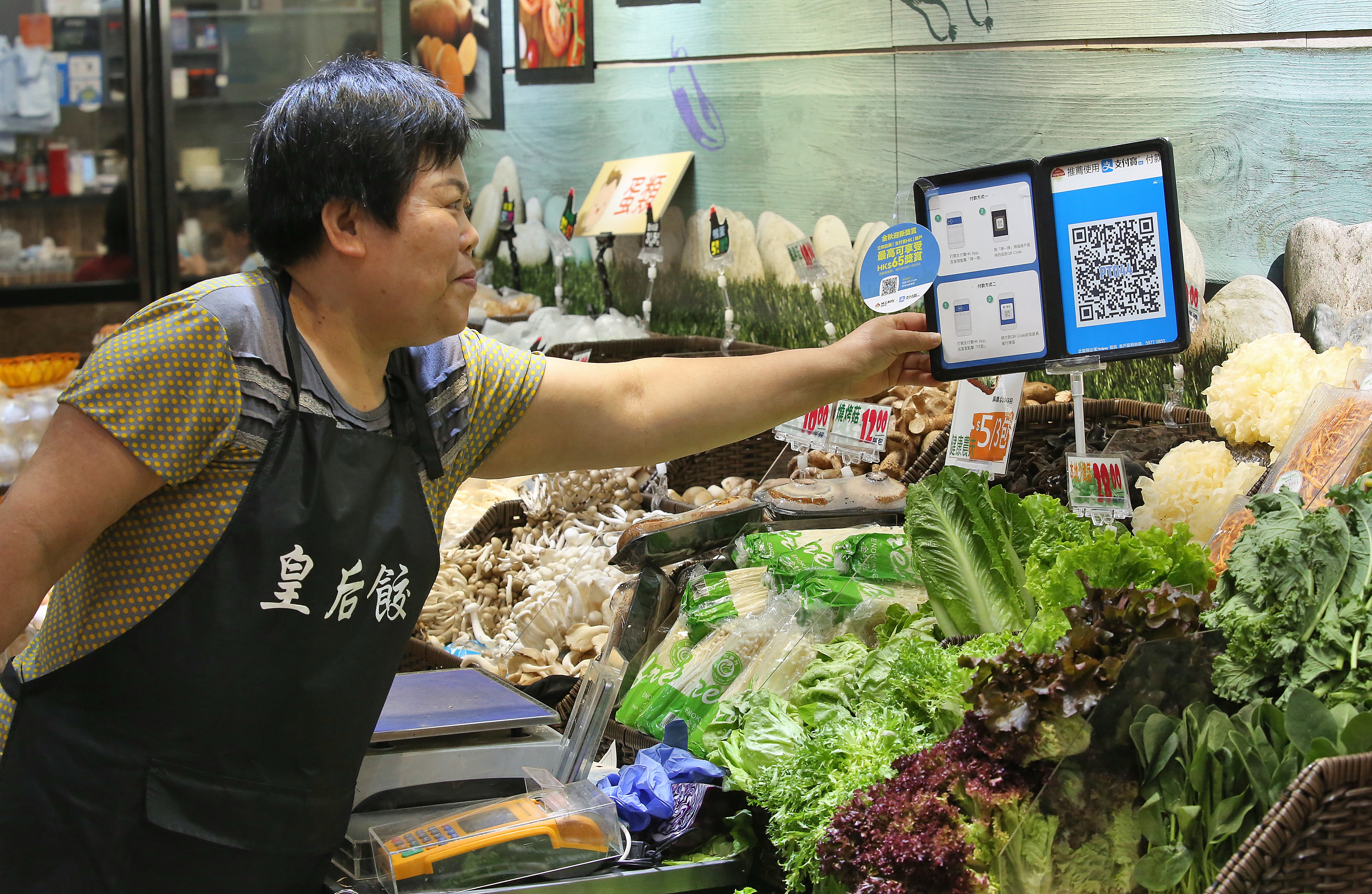 A merchant with a QR code payment system at a stall inside Po Tat Market in Sau Mau Ping. Photo: Edmond So