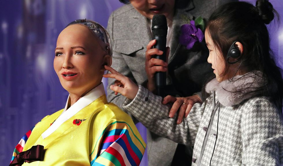 A child touches the robot Sophia, developed by a Hong Kong-based company, during a conference on artificial intelligence in Seoul. As machines threaten to displace human beings from some jobs, cultivating creativity in children has become more crucial. Photo: Yonhap