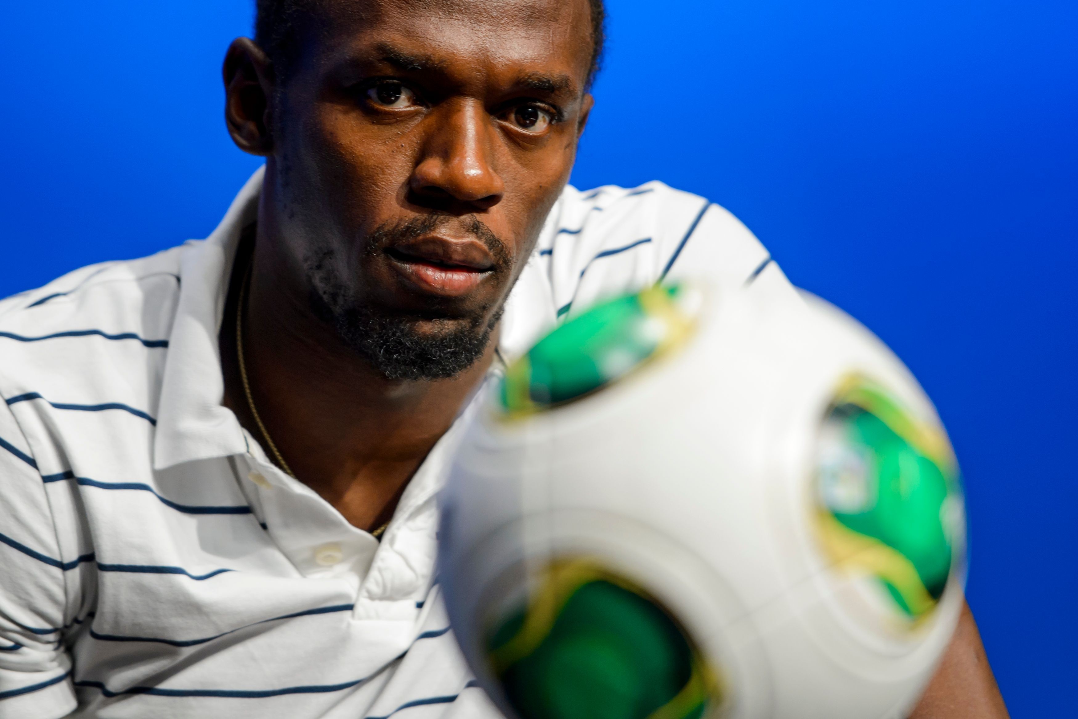 Jamaica's Usain Bolt looks at a ball during a visit to Fifa headquarters in 2013. Photo: AFP