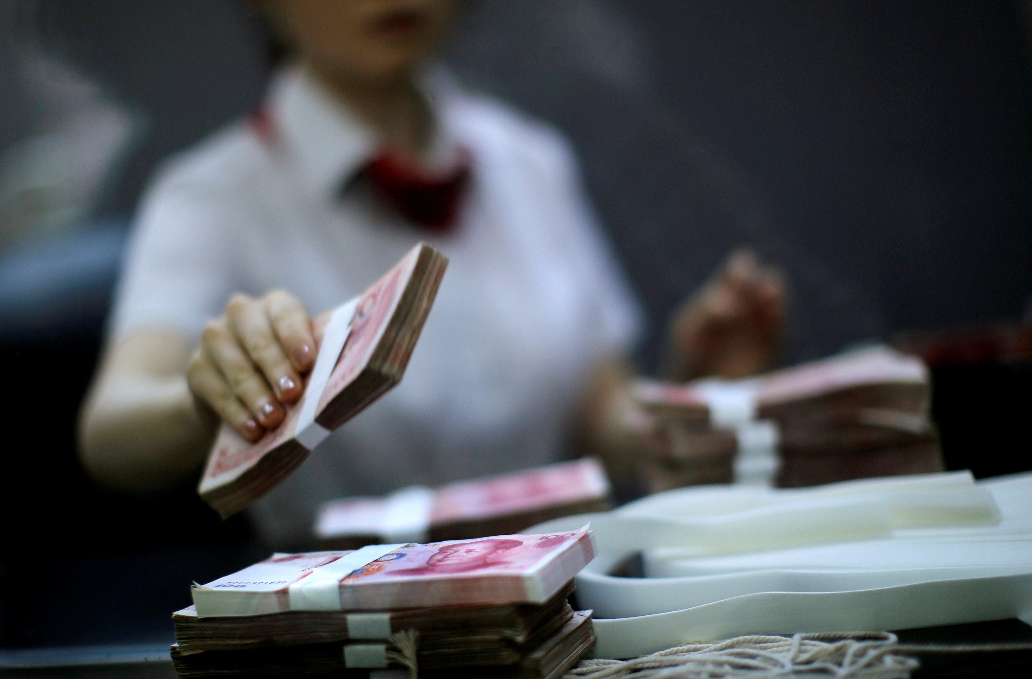 An employee of the Industrial and Commercial Bank of China Ltd (ICBC) counts money at one of the bank's branches at the Shanghai Free Trade Zone in Pudong district, in Shanghai on September 24, 2014. Photo: Reuters