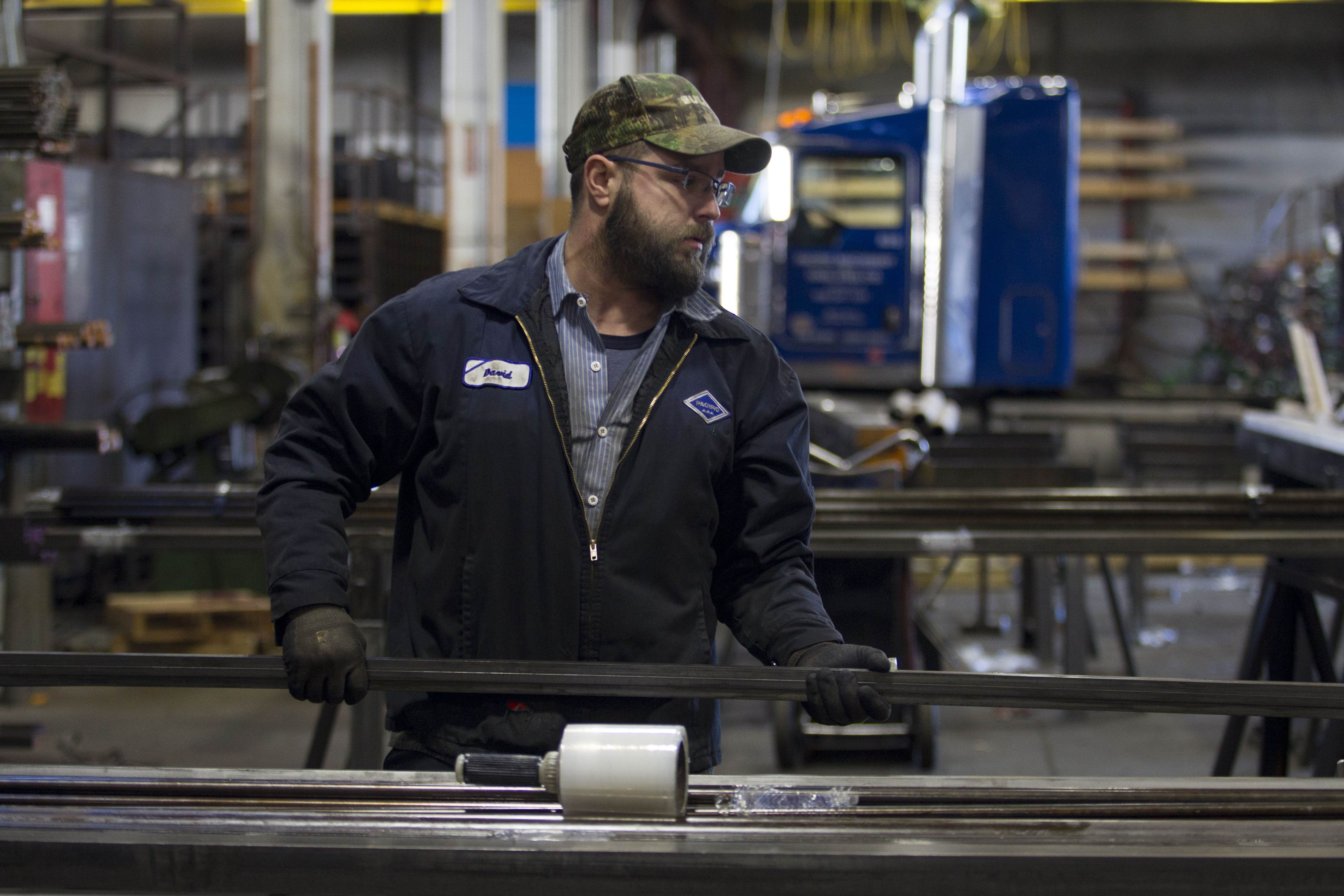 A factory worker carries bars of machine-grade steel in the Pacific Machinery & Tool Steel Company in Portland, US, on March 6. Photo: AFP