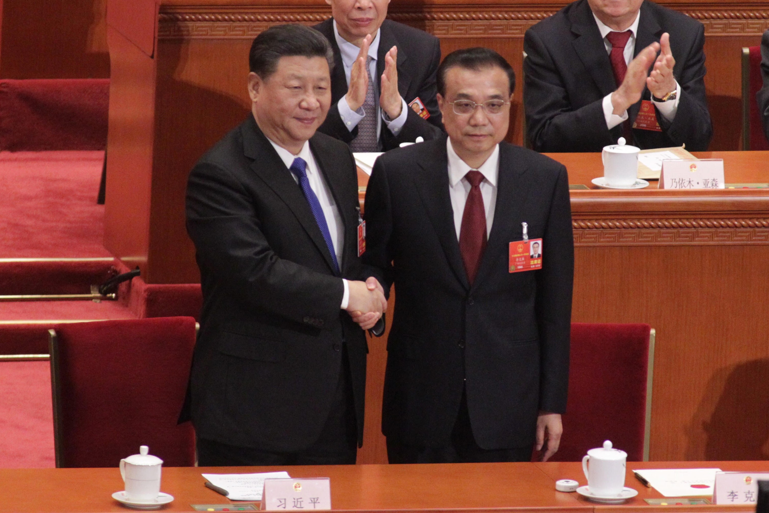 Premier Li Keqiang (right) shakes hands with President Xi Jinping at the Great Hall of the People in Beijing on Sunday after his government position was confirmed for another five years. Photo: Simon Song