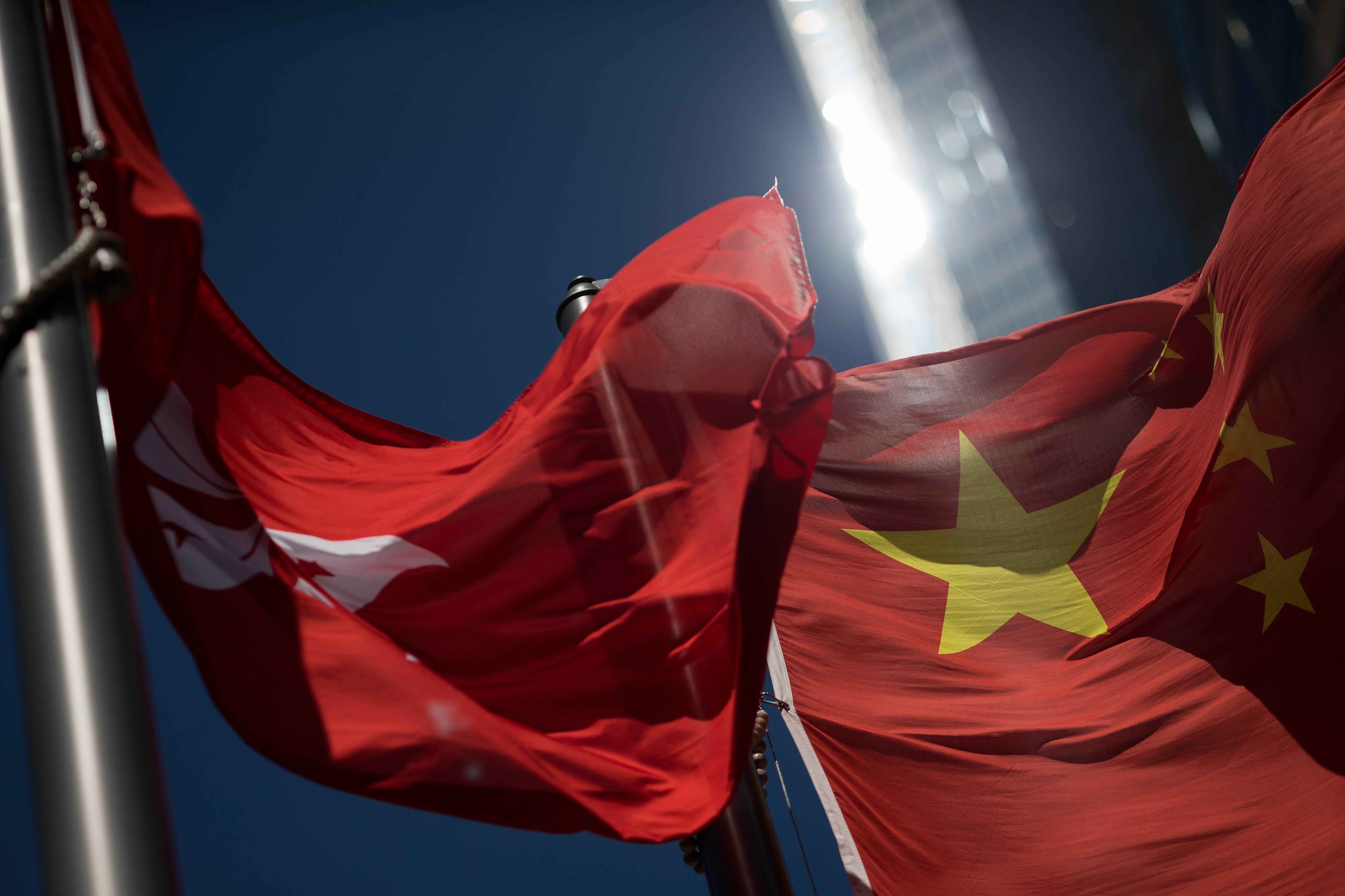 The Hong Kong and China flags flutter side-by-side, outside the Hong Kong stock exchange. Photo: EPA