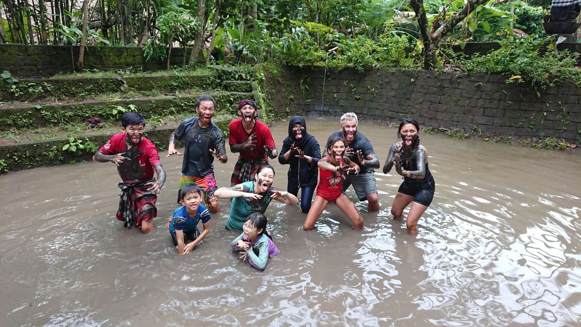 Cherry Chau’s son (front left) and her husband (behind) in a Balinese mud game with locals during their one-month stay in Indonesia. Photo: Handout