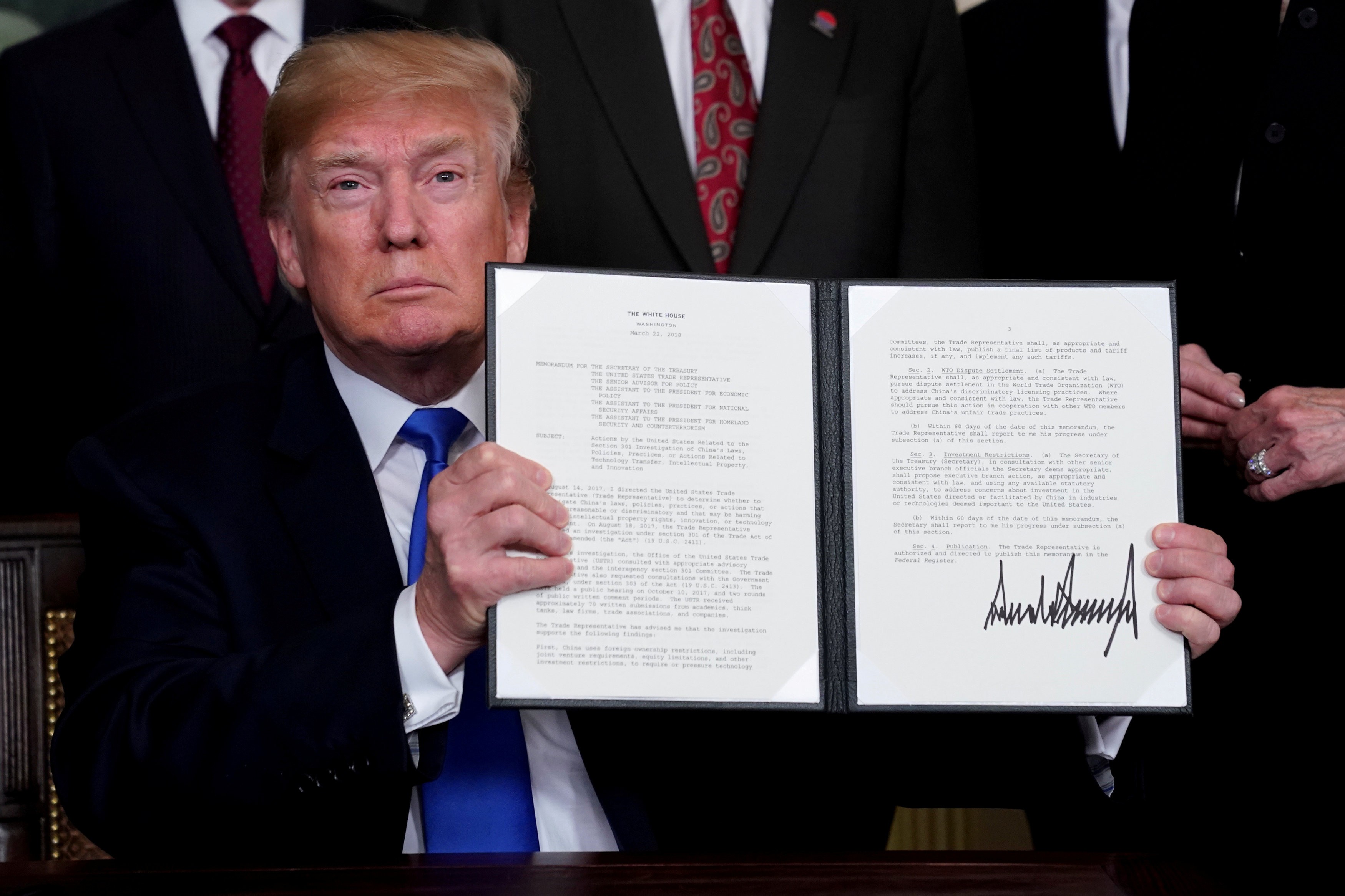 United States President Donald Trump holds his signed memorandum on intellectual property tariffs on hi-tech goods from China, at the White House in Washington, on March 22, 2018. Photo: Reuters