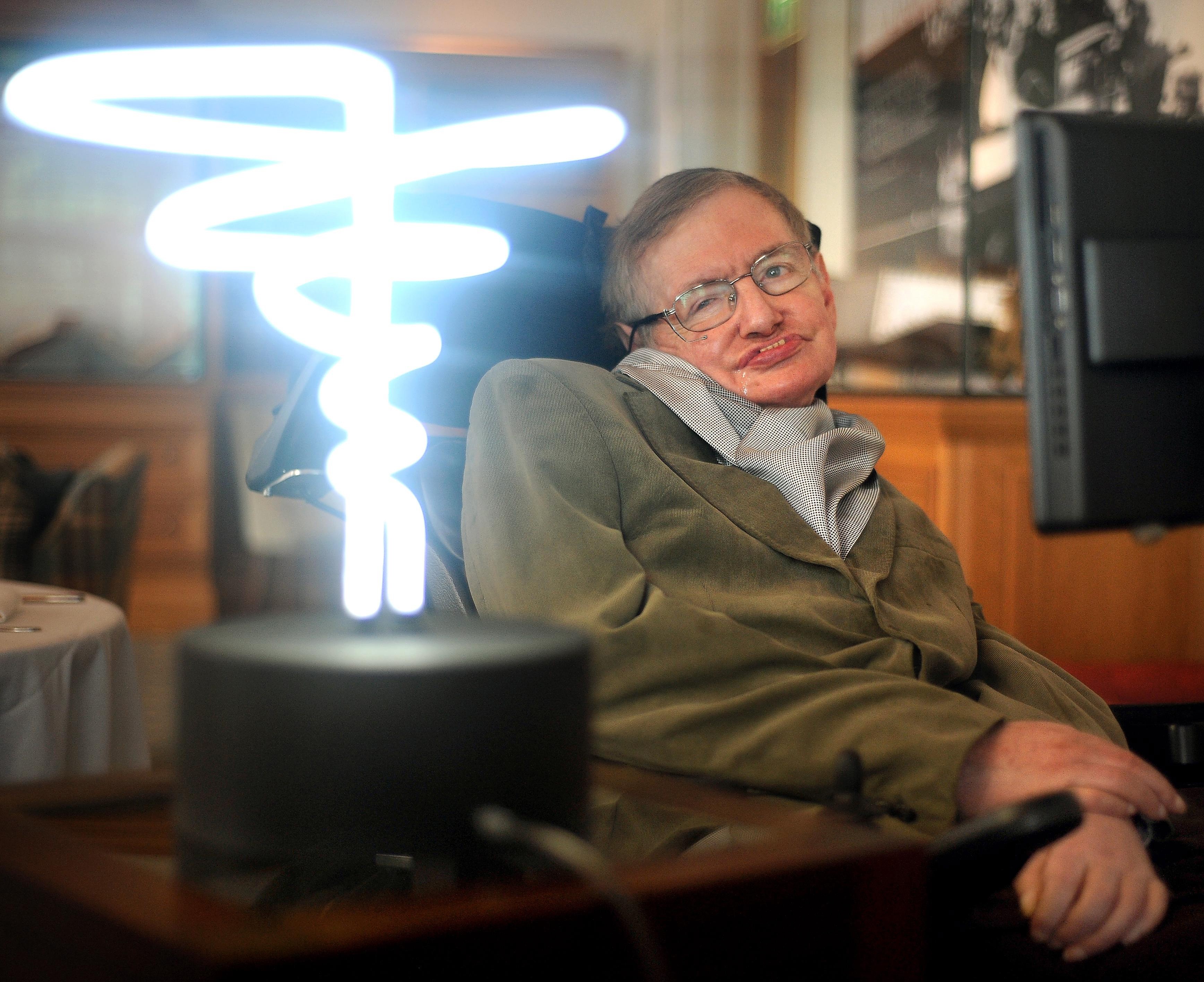 In this February 25, 2012 photo, Professor Stephen Hawking poses beside a lamp titled “black hole light” by inventor Mark Champkins, presented to him during his visit to the Science Museum in London. Photo: AP