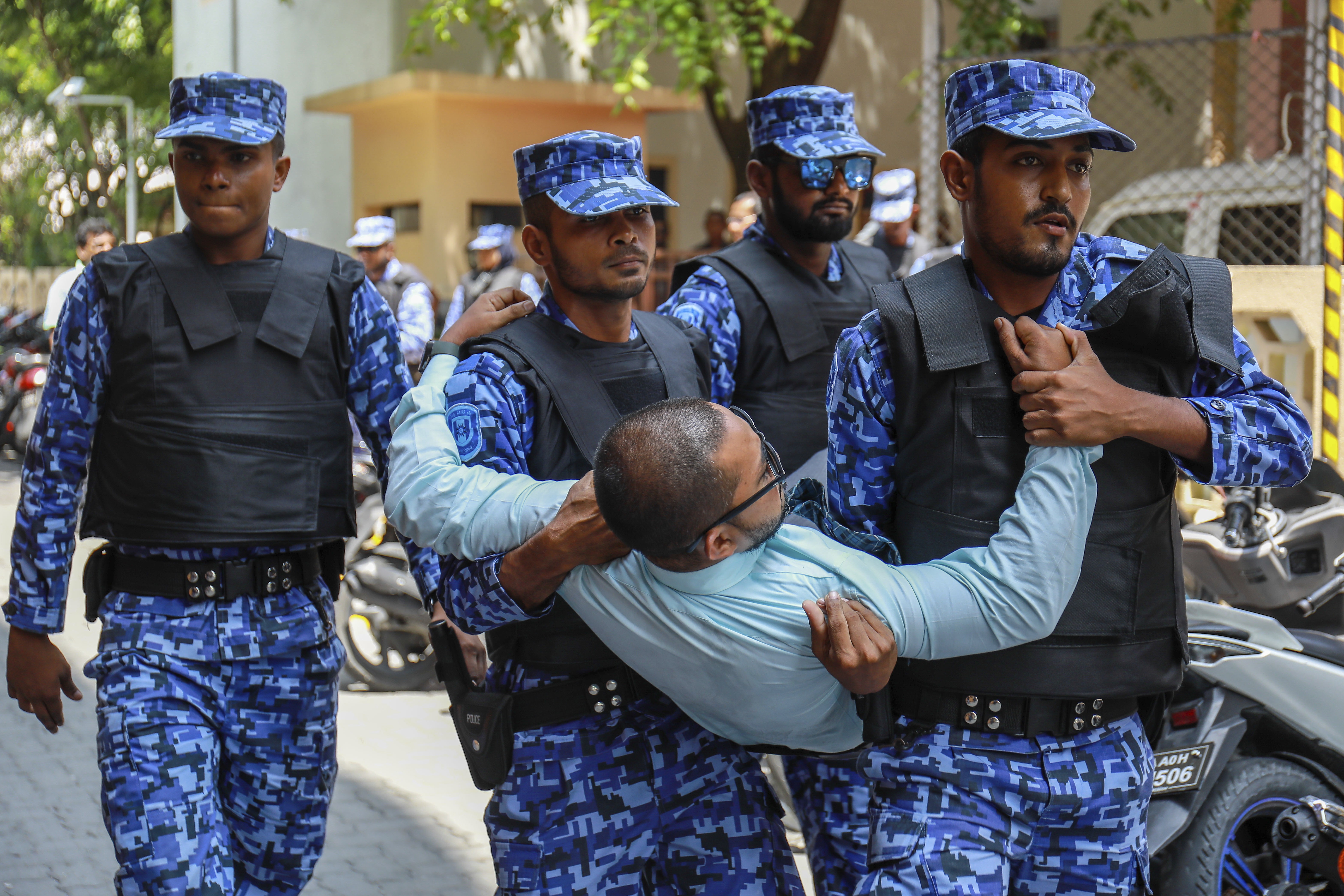 Maldivian police remove an opposition member who tried to enter a Parliament building that closed following the state of emergency. Photo: AP