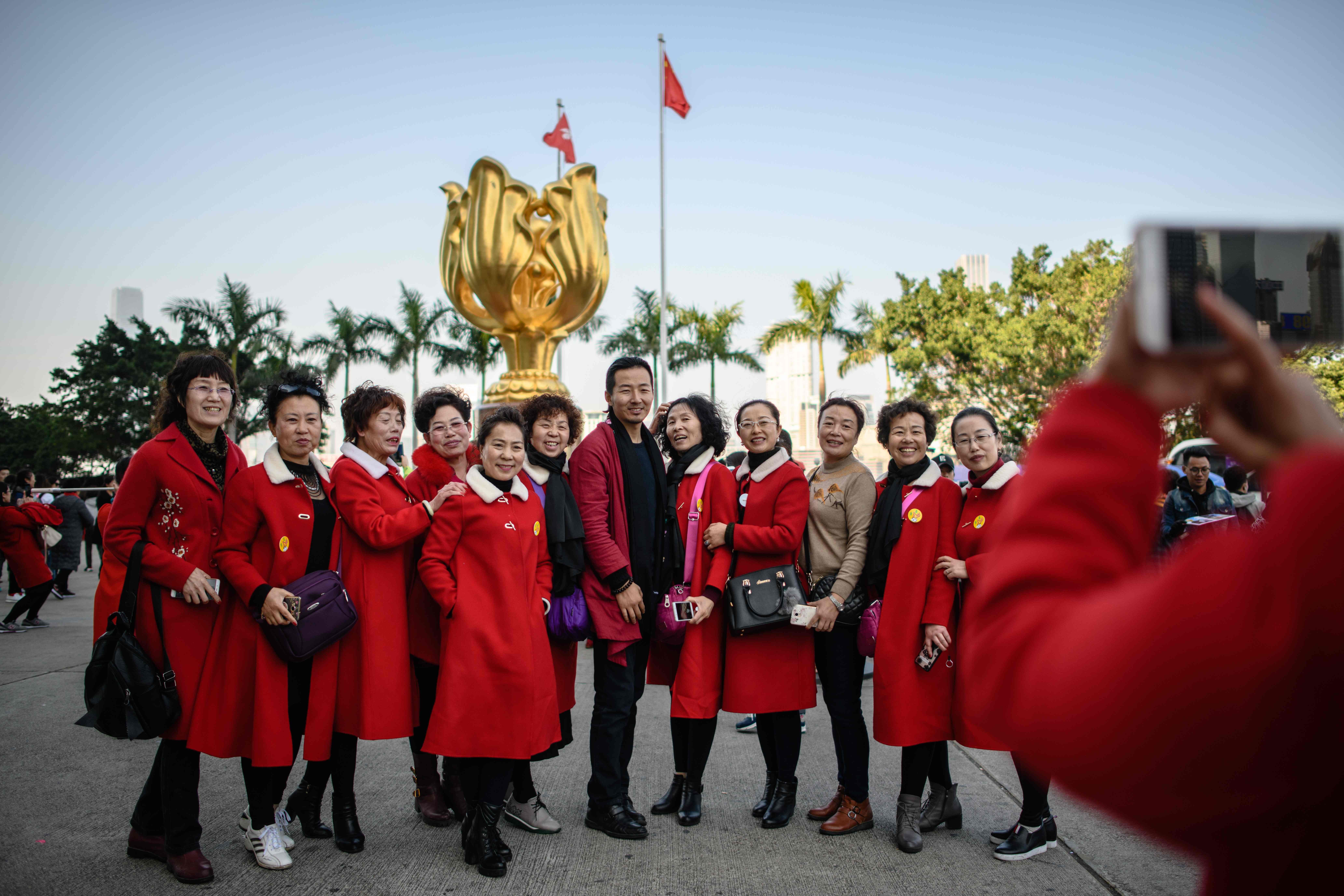 Tourists from mainland China pose for photos in front of the Golden Bauhinia statue, a gift from the central government to Hong Kong in 1997 to celebrate the city’s return to Chinese sovereignty, in Wan Chai in December 2017. Photo: AFP 