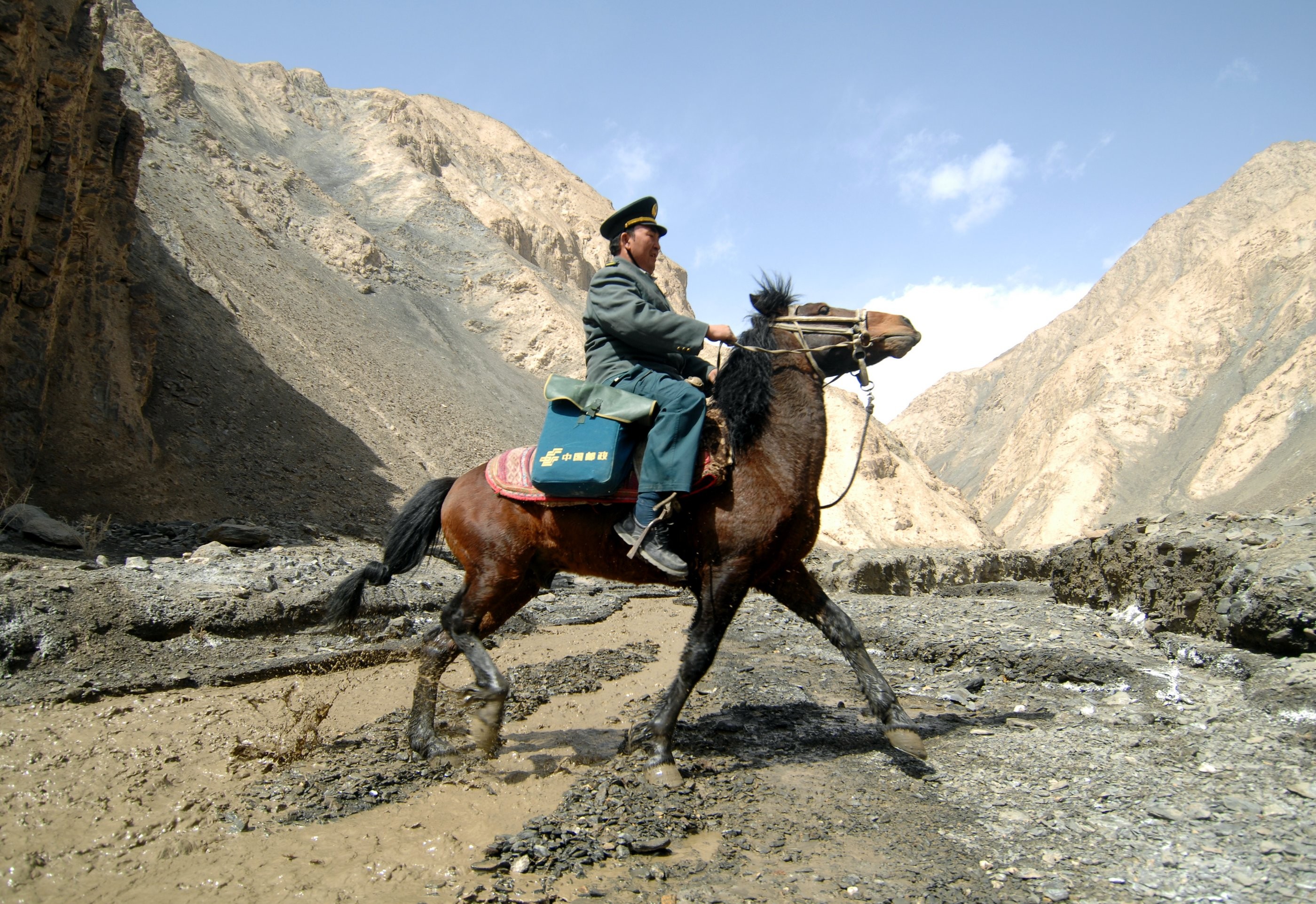 A postman goes on his rounds in the Pamir Mountains in the remote western region of China, serving more than 5,000 nomads across 2,200 sq km, in March 2012. The Universal Service Obligation strives to ensure that everyone has access to postal services. Photo: Xinhua 