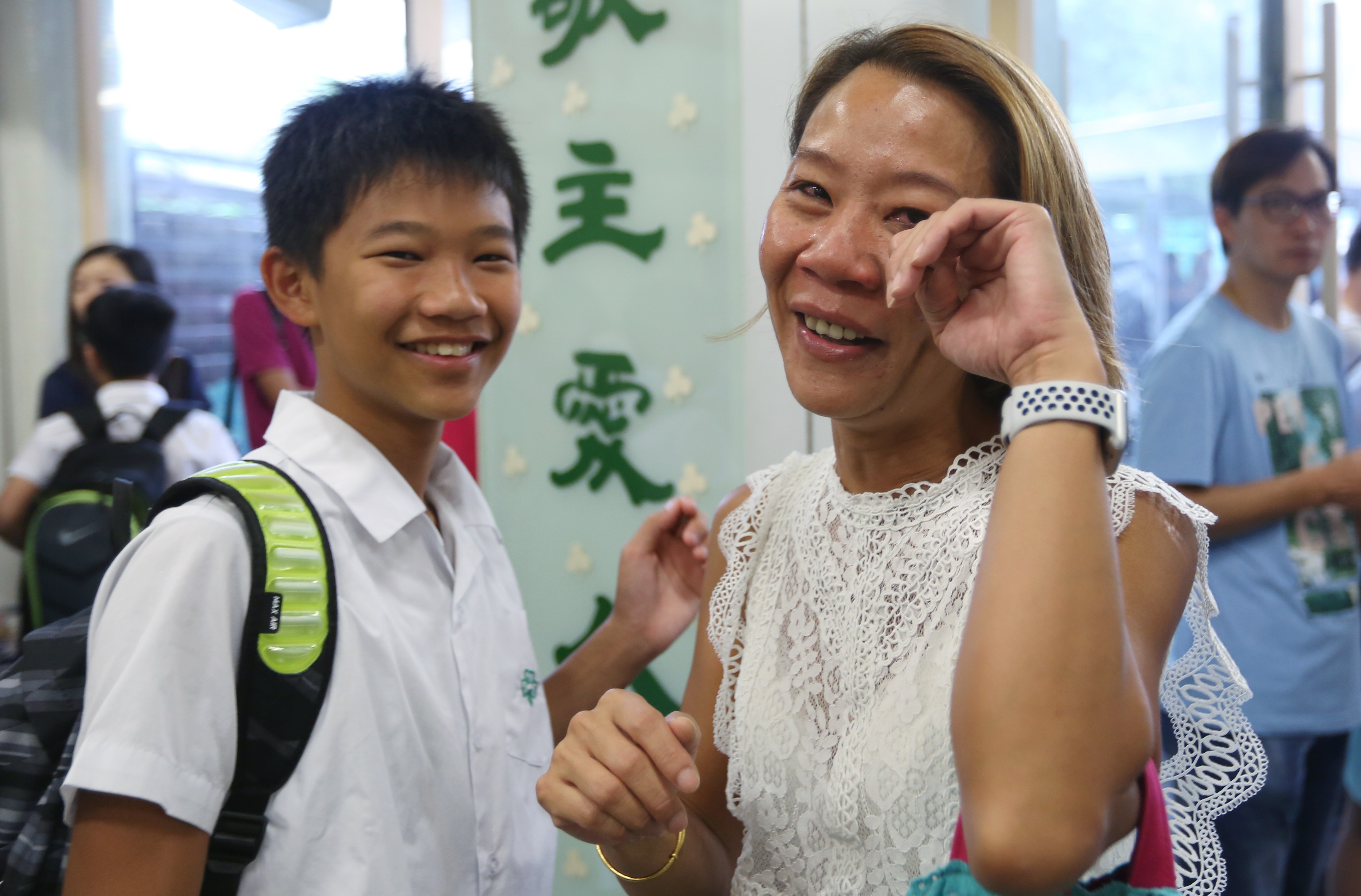 Cheng Suk-fan (right) cries tears of joy after discovering her son Yuen Pak-ngai, 12, has been accepted by Choi Hung Catholic Secondary school, his first choice. Photo: Xiaomei Chen