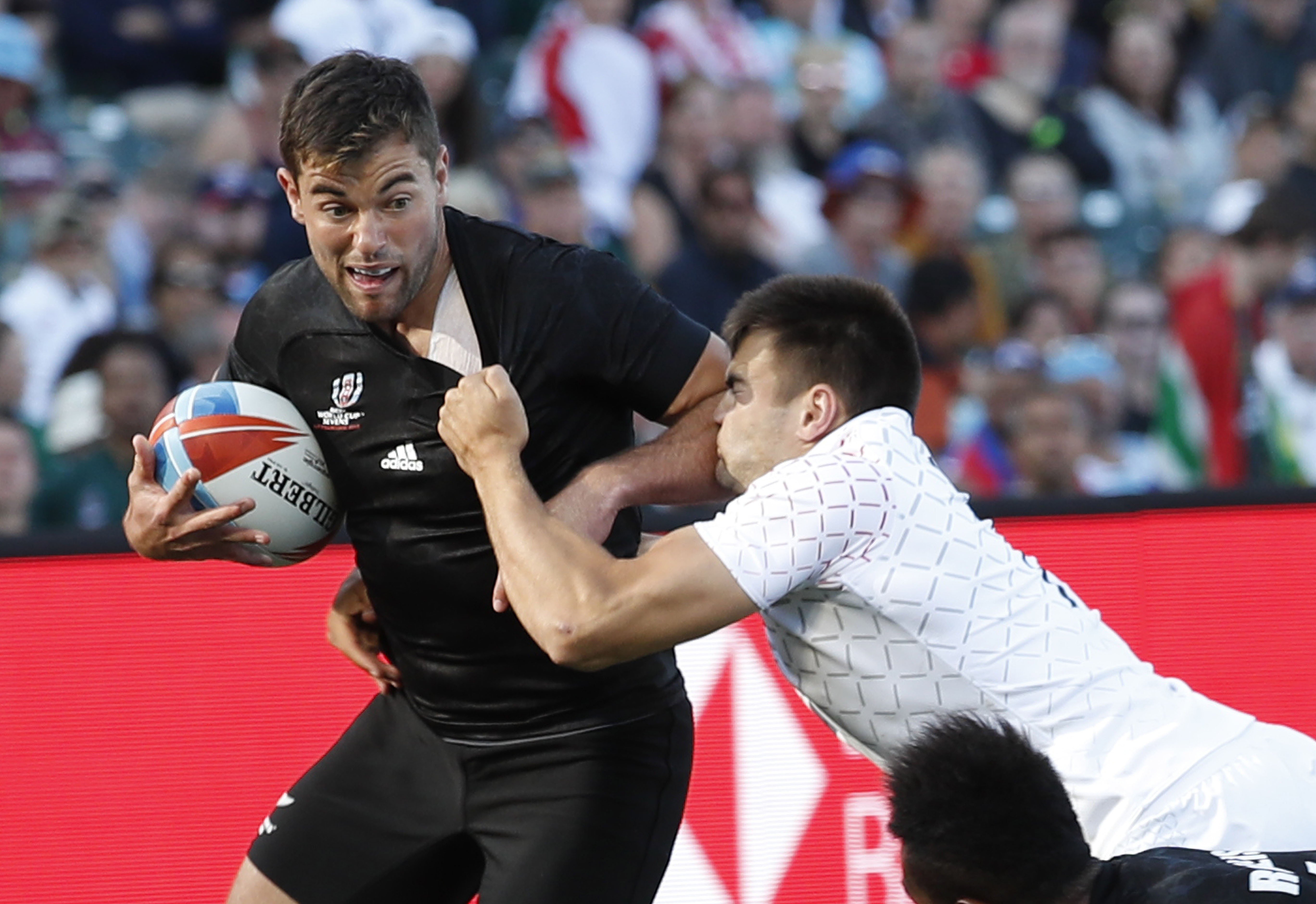 Andrew Knewstubb (left) of New Zealand holds off England’s William Muir during the Rugby World Cup Sevens final. Photo: EPA