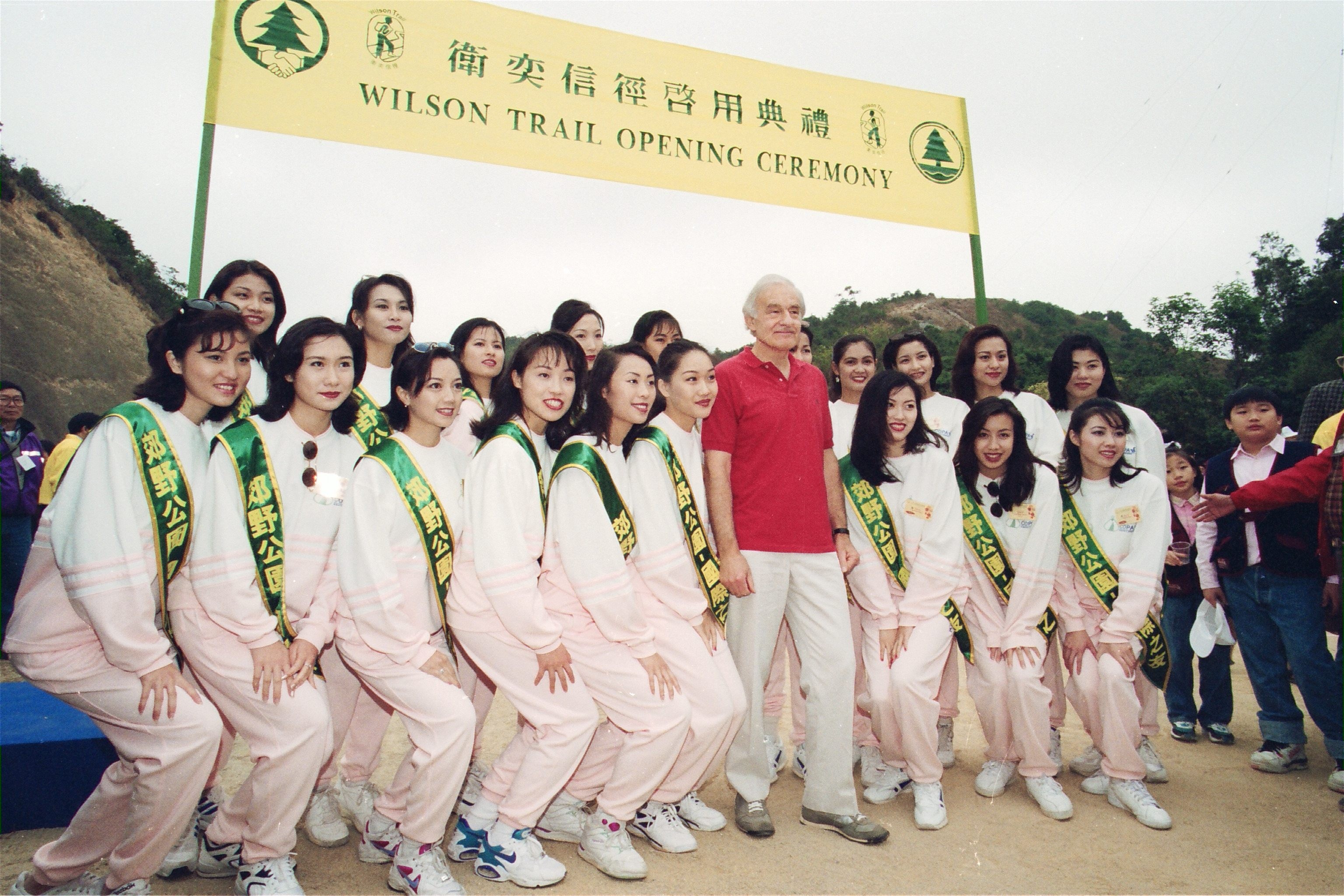 David Wilson poses for a picture with the contestants in the Miss Chinese International beauty pageant during the opening ceremony of the Wilson Trail at the Kam Shan Country Park. Photo: SCMP Pictures