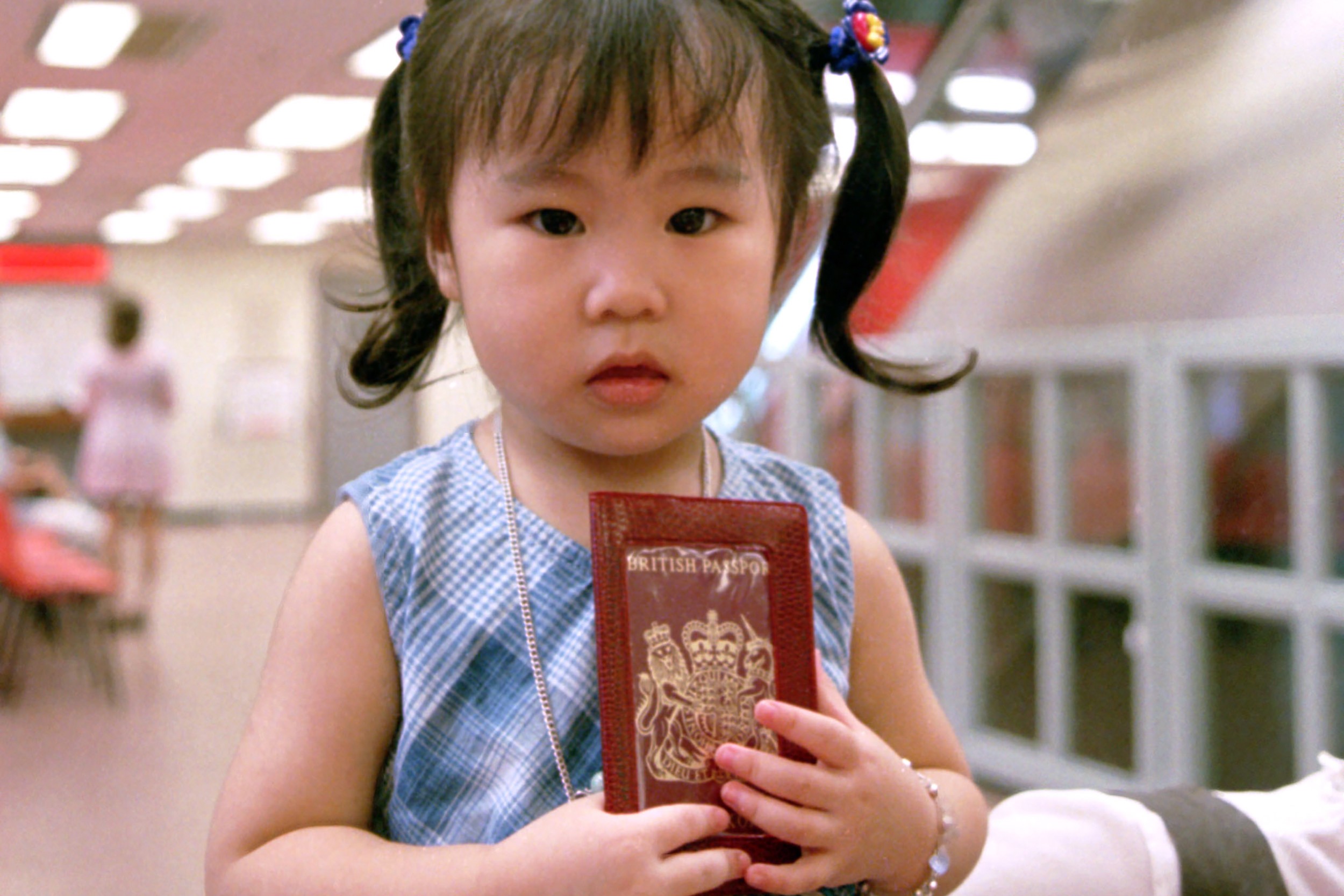 A two-year-old girl clutches her passport at the Immigration Department in 1995. Parents were signing their children up in droves to obtain British National (Overseas) passports ahead of the city’s return to Chinese rule in 1997. Photo: SCMP