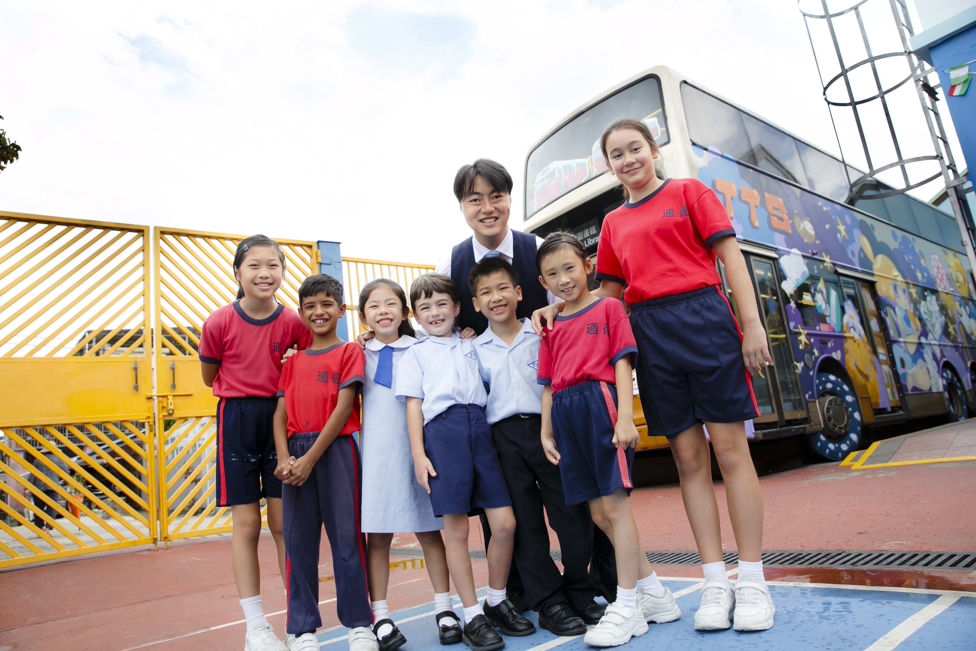 Principal Wong Wai-lap (back centre) with primary schoolchildren in front of their KMB bus library at Tung Tak School in Hong Kong’s New Territories. Photo: Raymond Mak
