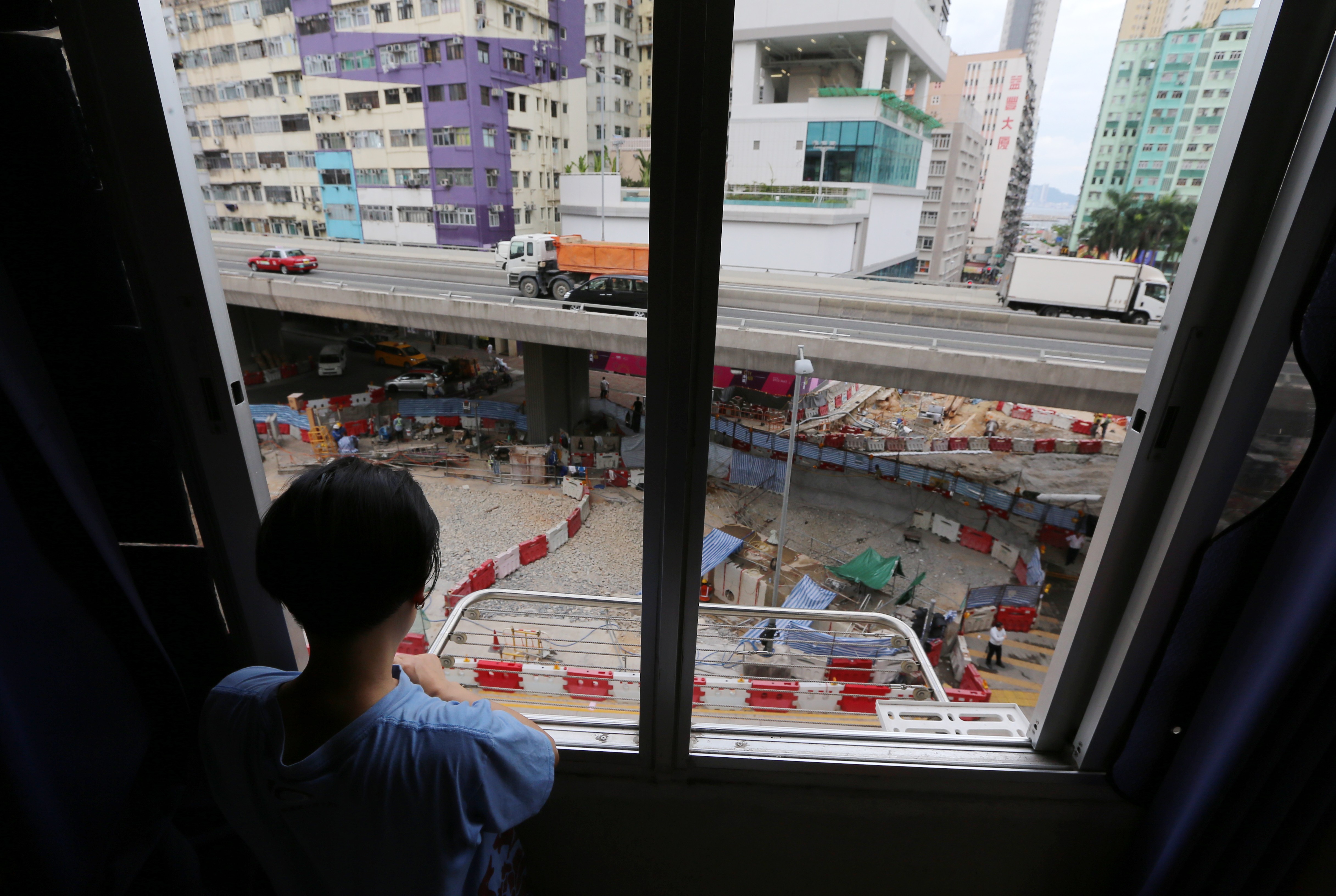 Lily Yeung looks out at the construction in To Kwa Wan which has affected nearby residential buildings. Photo: Dickson Lee