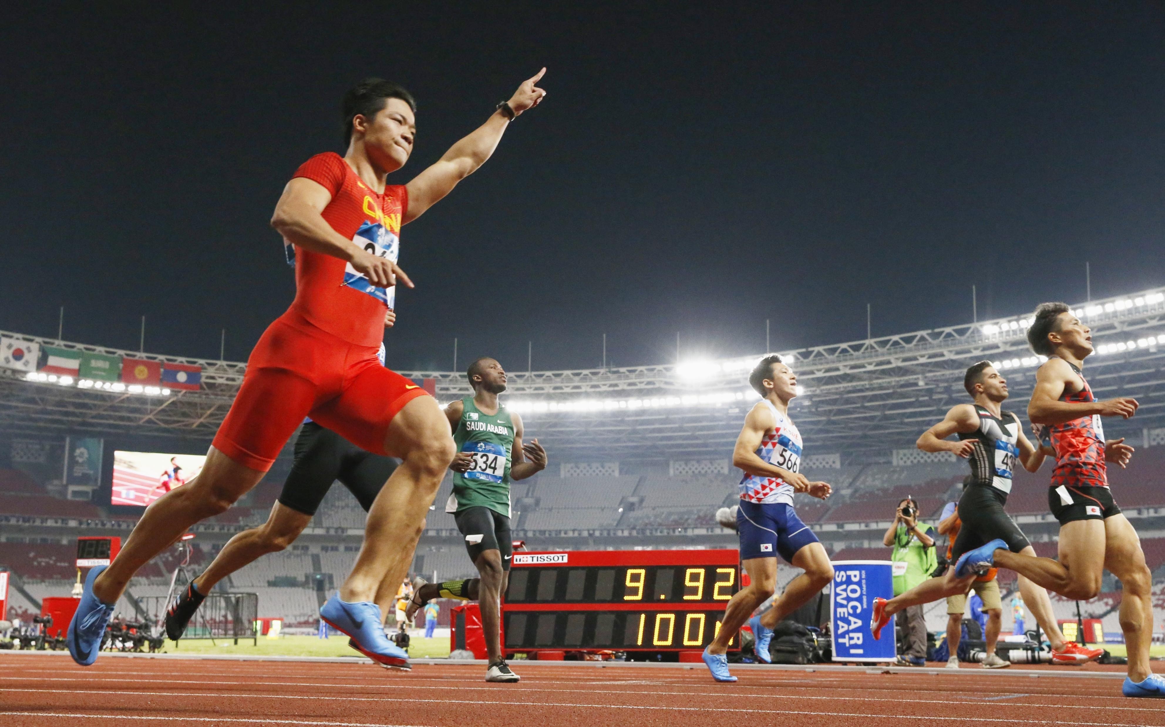 Su Bingtian raises his hand in triumph after winning the 100 metres. Photo: Kyodo