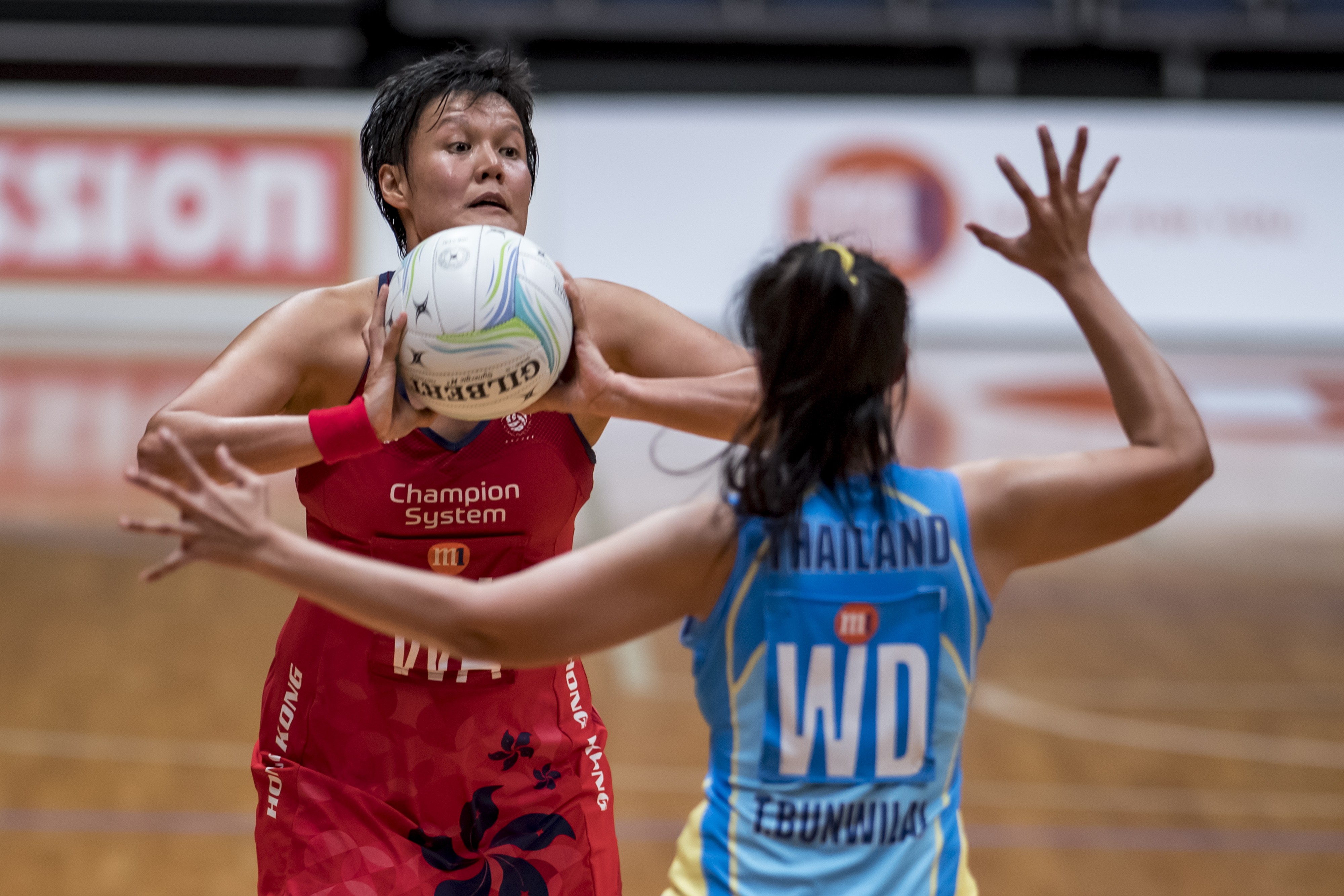 Connie Wong prepares to pass for Hong Kong against Thailand. Photos: Netball Singapore