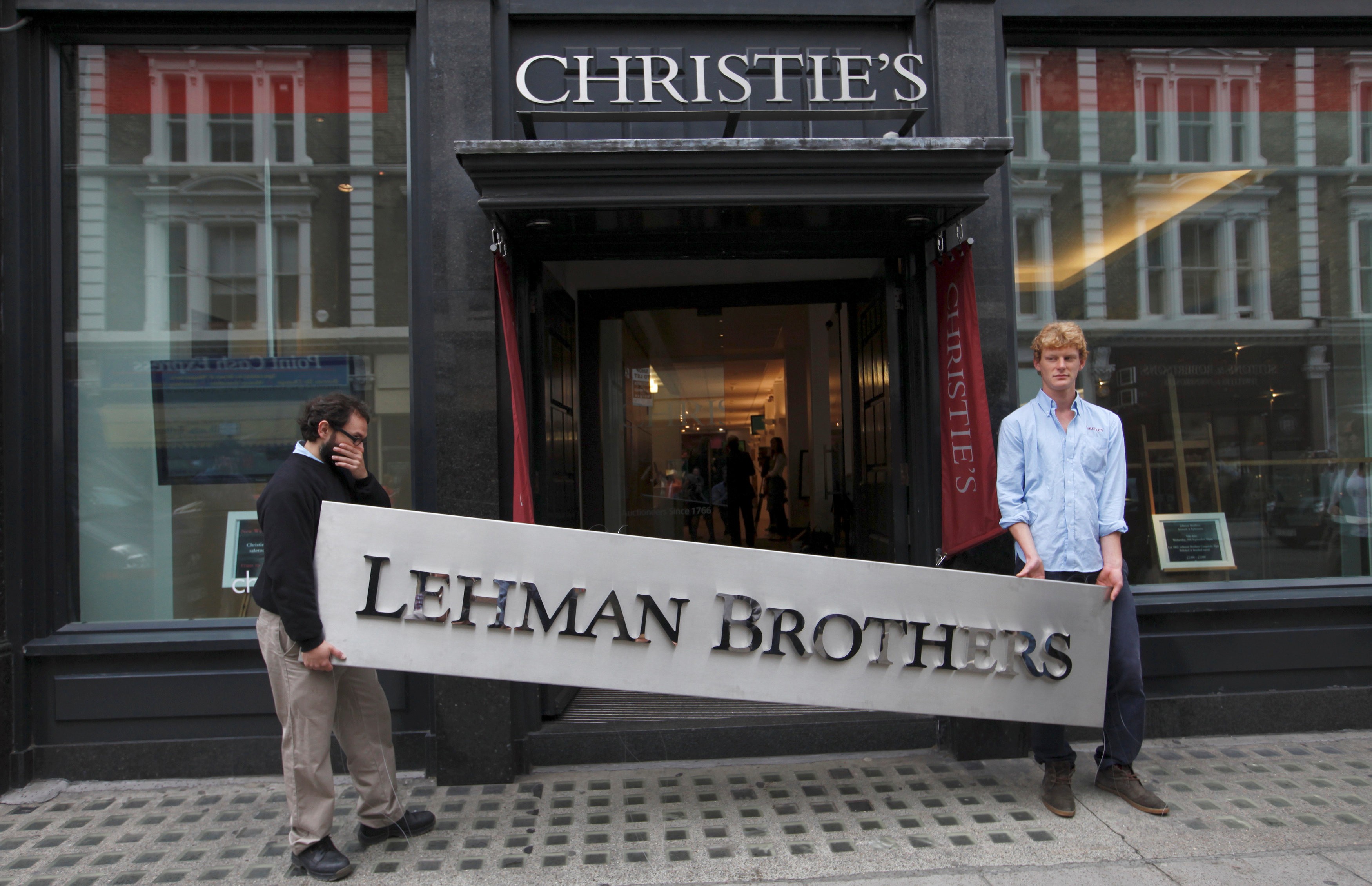 Christie's employees carry a Lehman Brothers sign at the auction house’s offices in central London in this file photo from September 24, 2010. Photo: Reuters