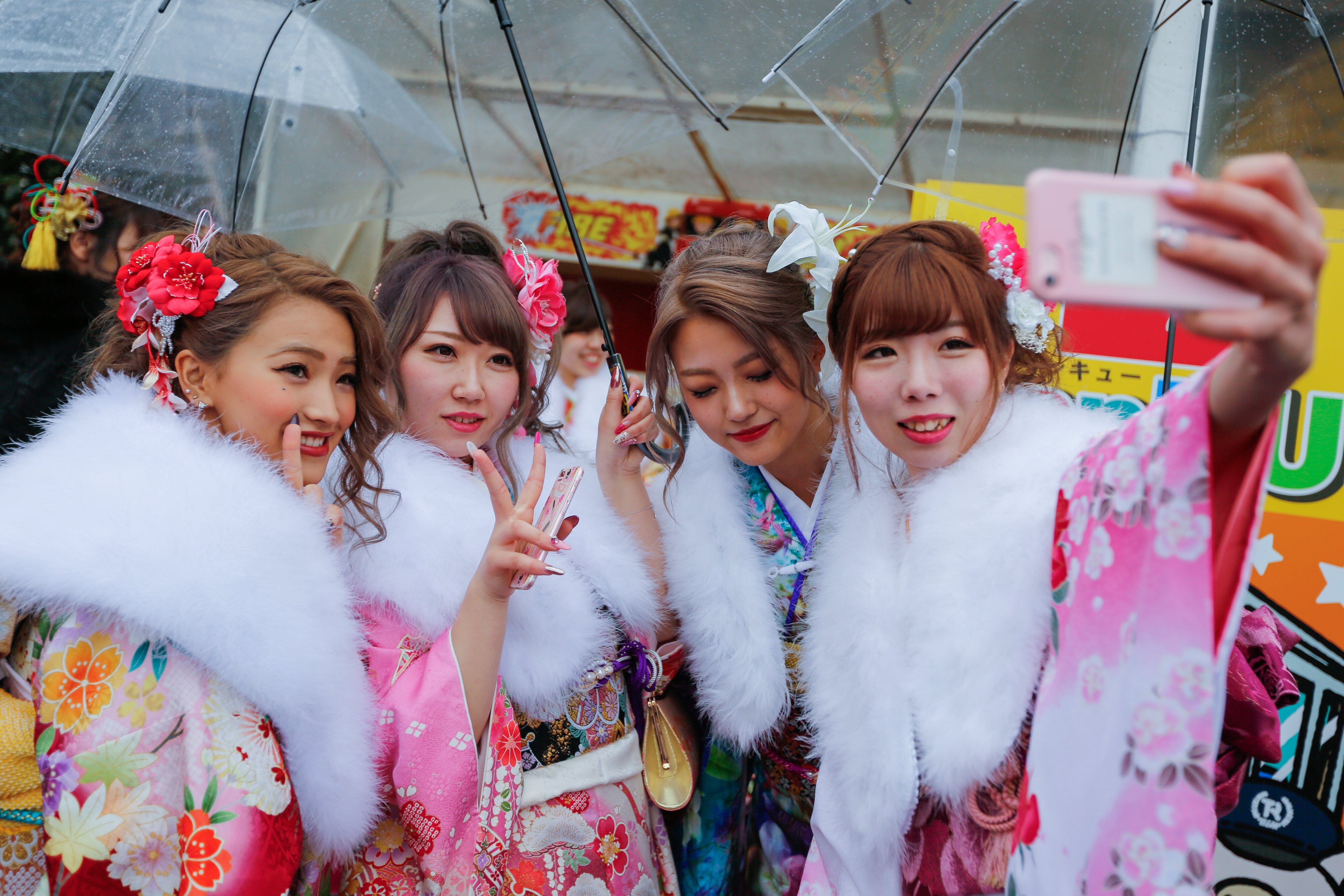 Young Japanese women take a wefie on Coming of Age Day. Female adults have a rough time in Japan. They are paid a third less than men for similar work. Photo: EPA