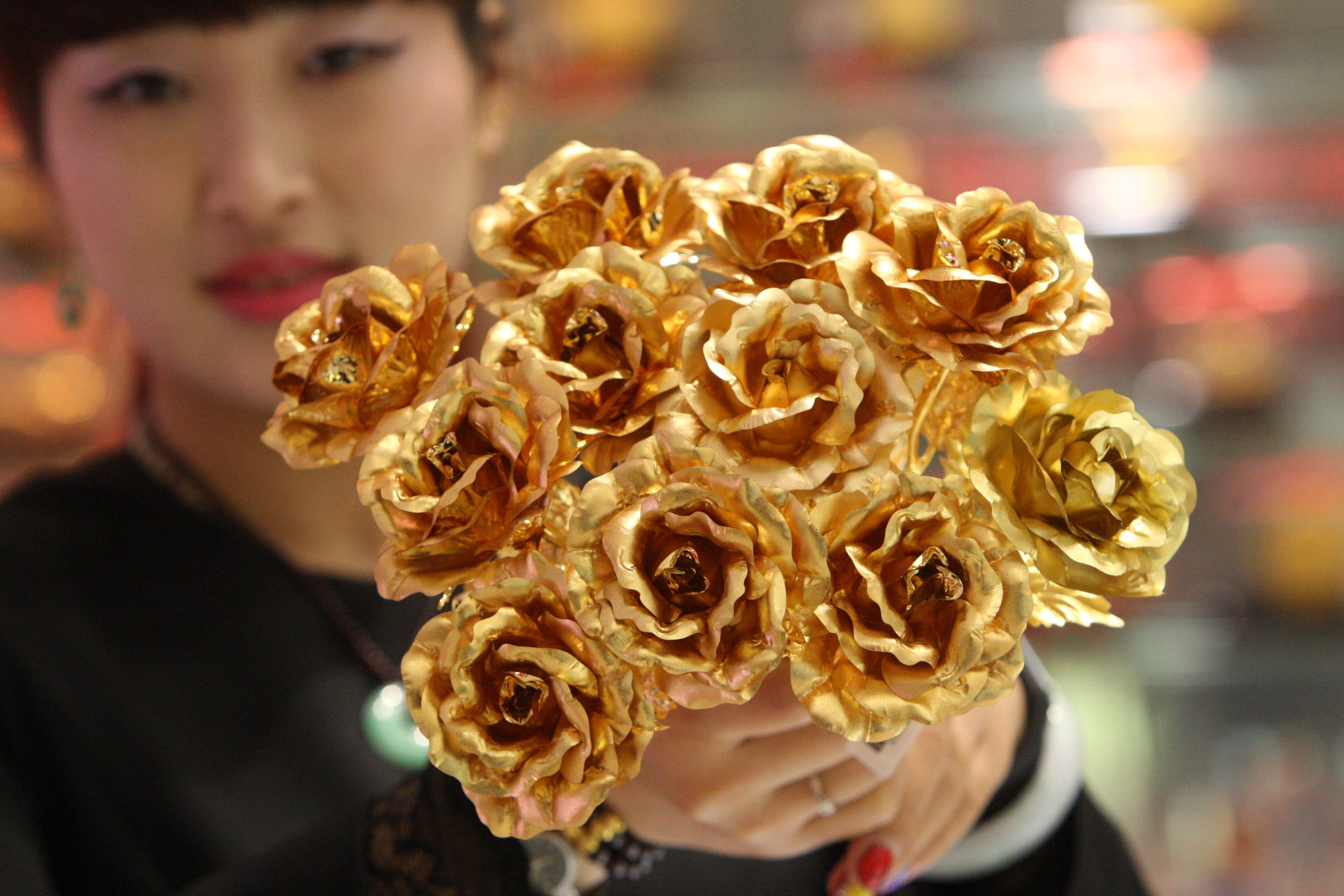 A worker shows off gold foil roses, a popular Valentine’s Day gift, at a shop in Yantai, in east China’s Shandong province, in February 2016. Chinese consumers tend to have a high appetite for the noble metal. Photo: Xinhua