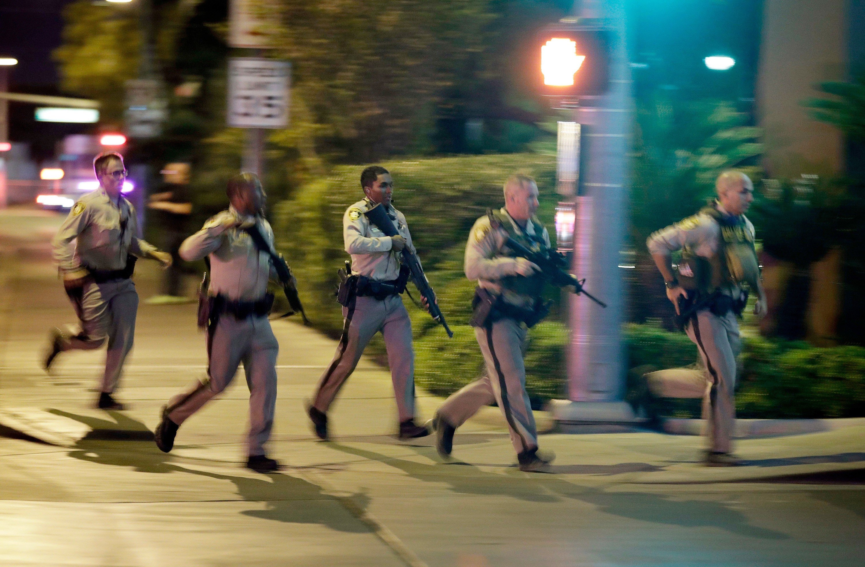Police run toward the scene of a shooting near the Mandalay Bay resort and casino on the Las Vegas Strip in Las Vegas on October 1, 2017. Photo: AP