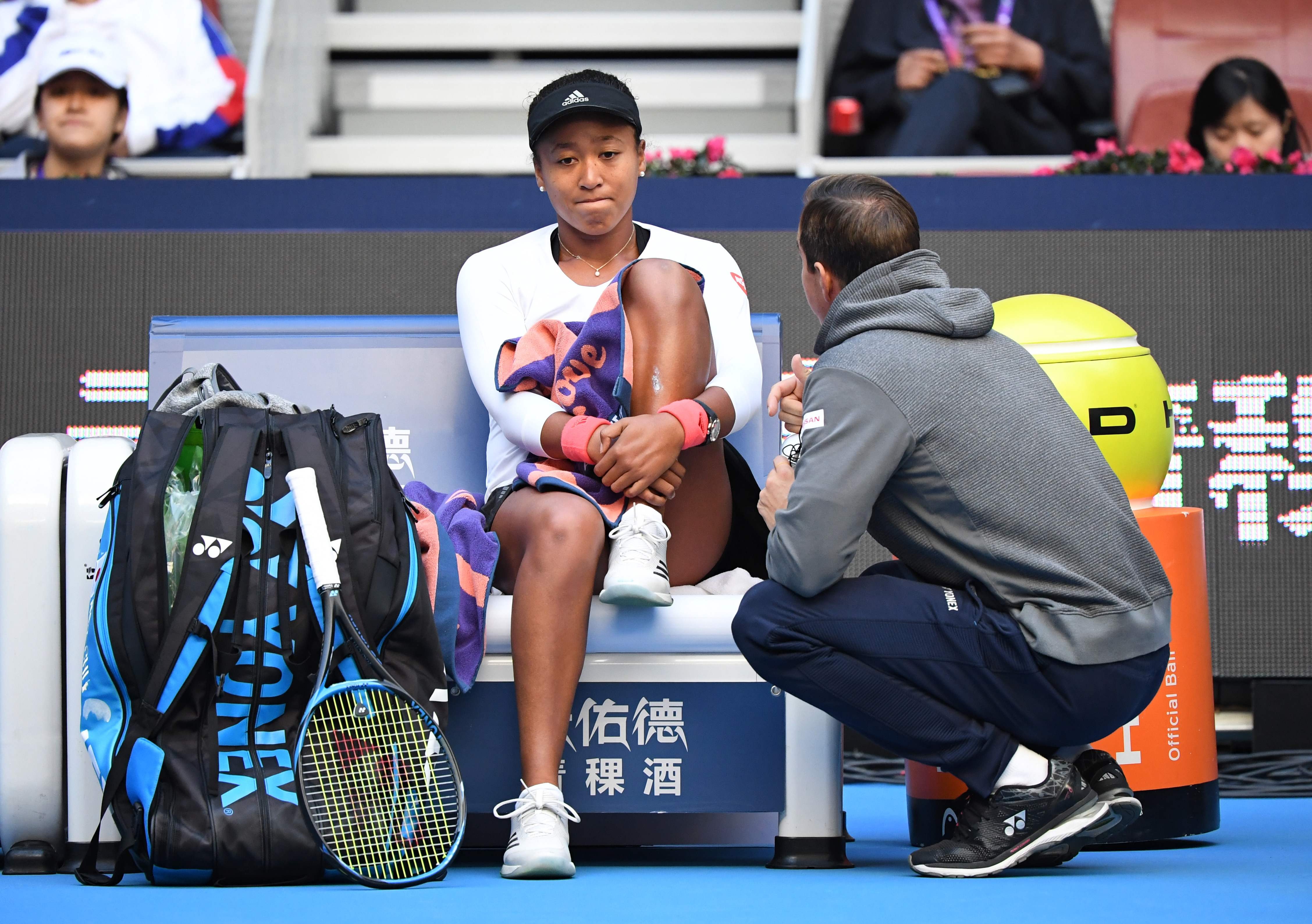 Naomi Osaka speaks with her coach during her semi-final against Anastasija Sevastova at the China Open in Beijing, during a match where she had treatment on her back. Photo: AFP