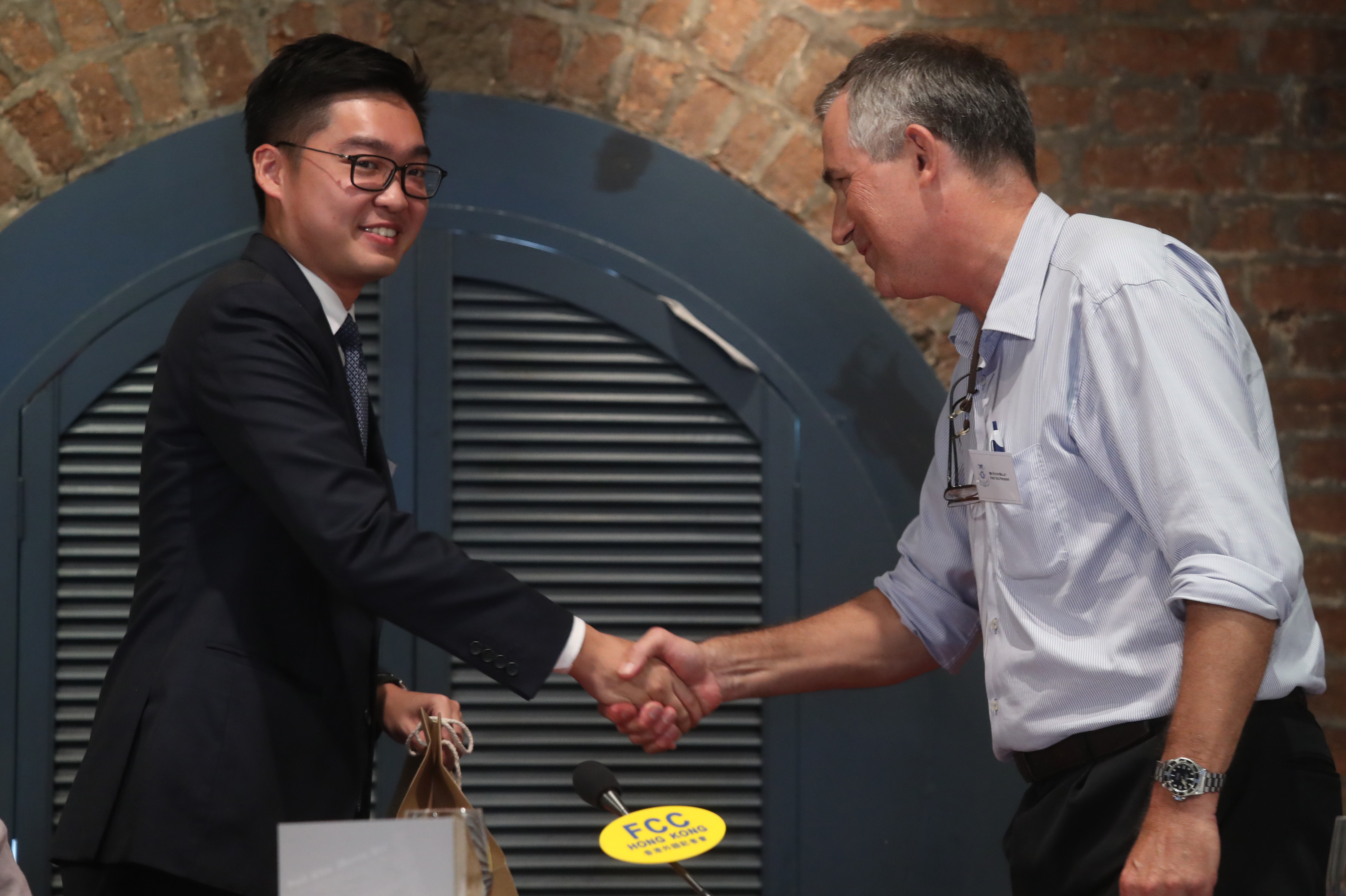 Separatist Andy Chan Ho-tin shakes hands with journalist Victor Mallet before his talk at the Foreign Correspondents' Club on August 14. Photo: K.Y. Cheng