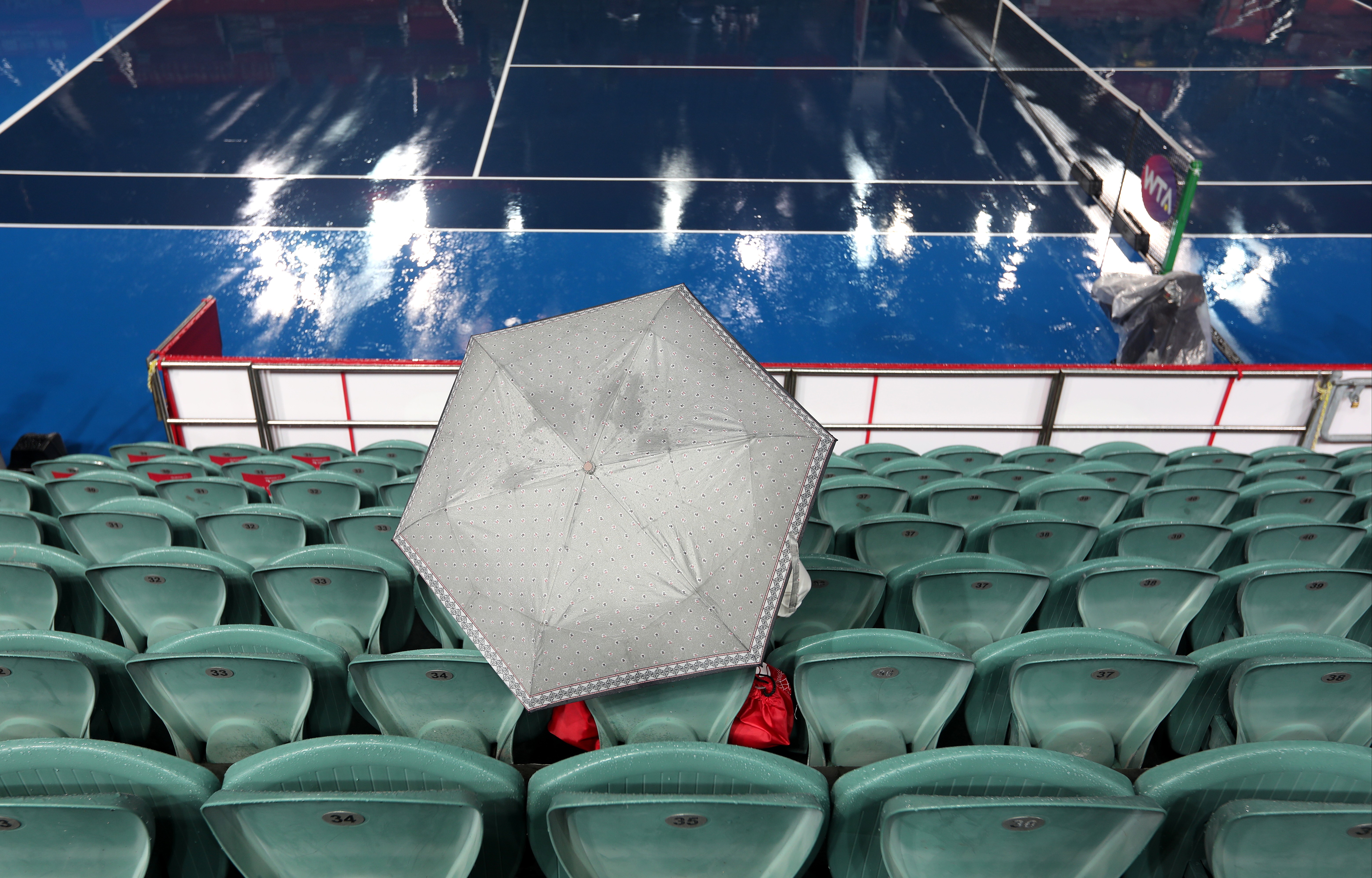 A spectator waits for the rain to stop on Centre Court at Victoria Park for the Prudential Hong Kong Tennis Open. Photos: Xiaomei Chen