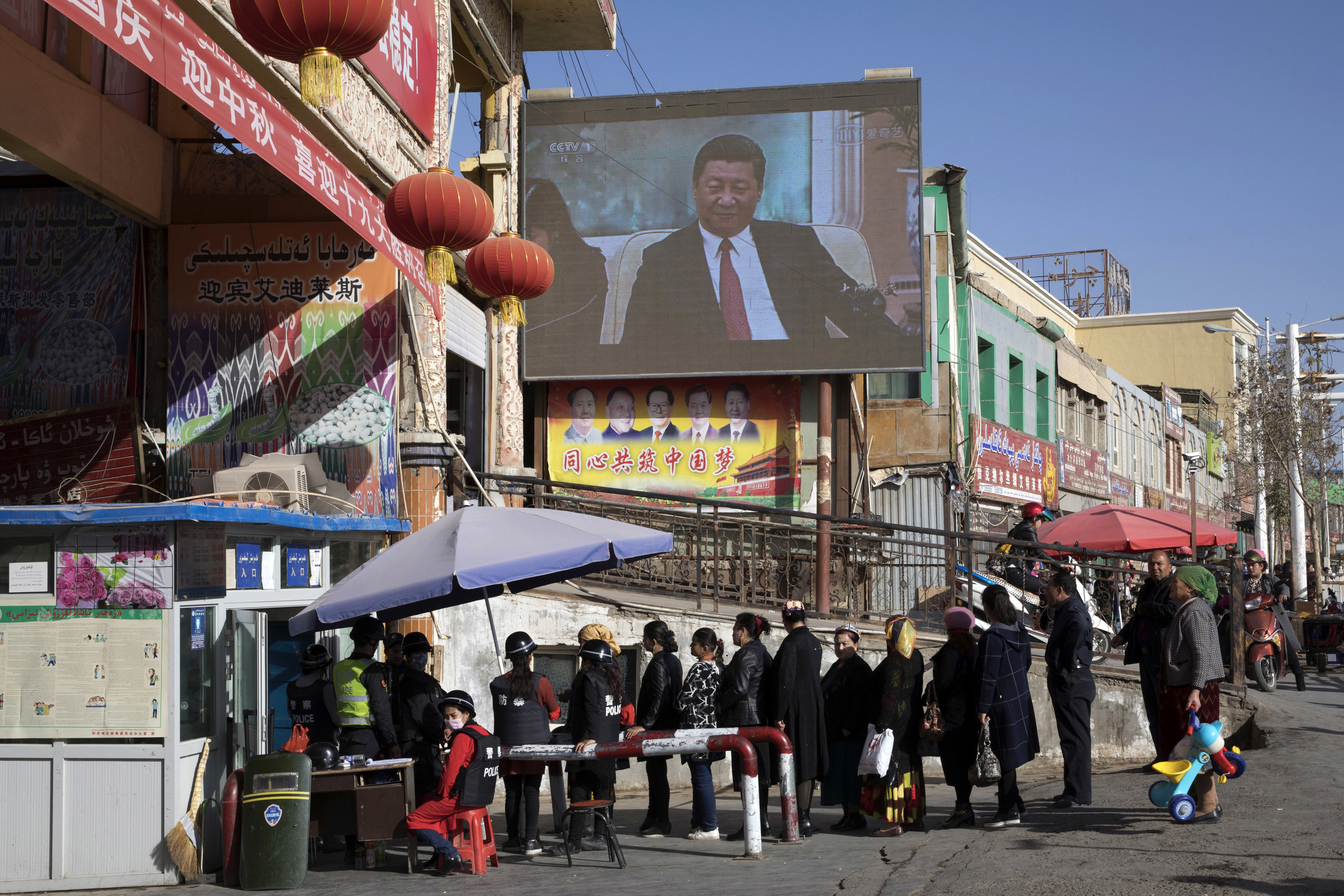 Residents pass through a checkpoint at Hotan bazaar in Xinjiang, part of the sweeping security crackdown in the region. Photo: AP