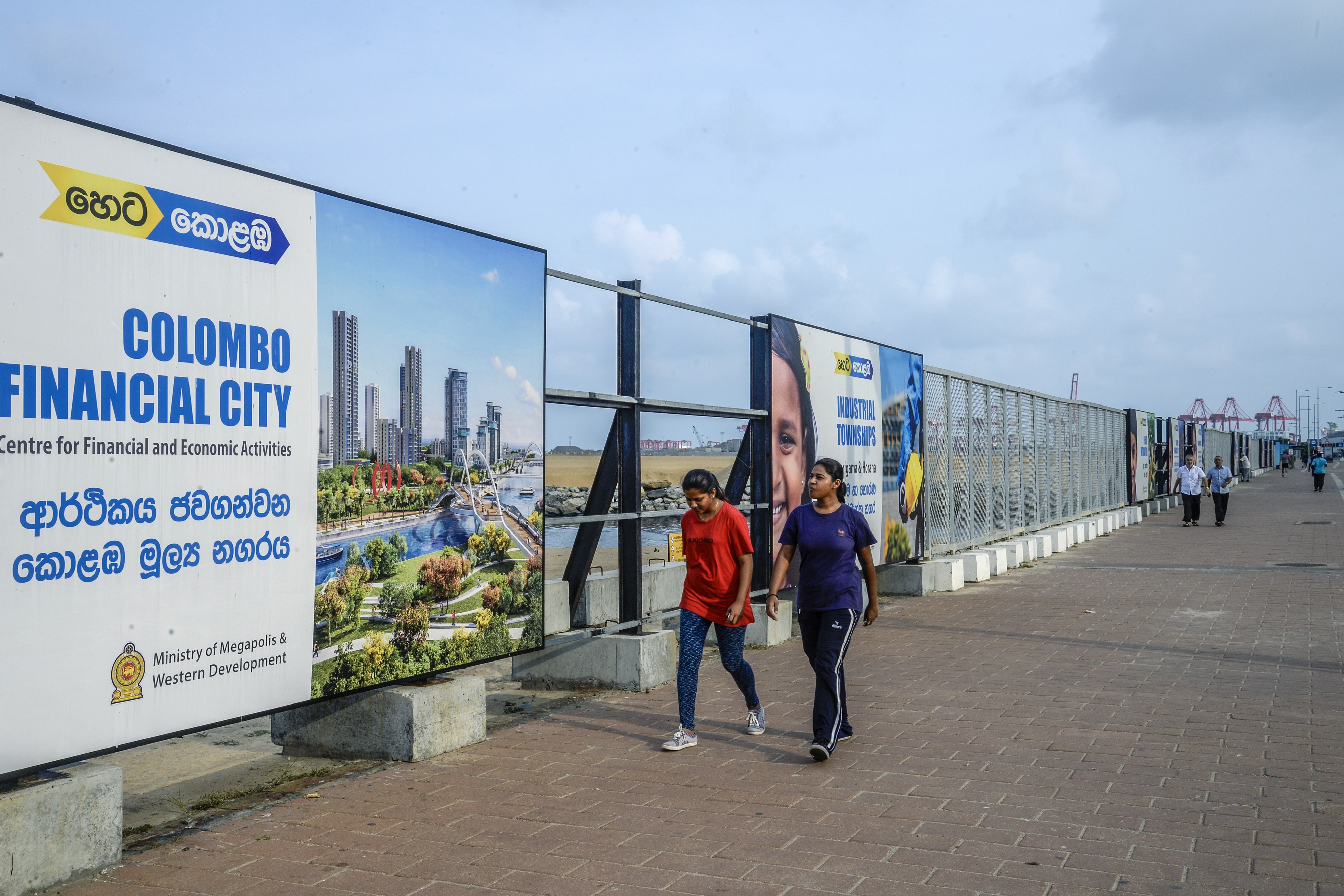 Pedestrians walk past signs for the Colombo International Financial City project in Colombo, Sri Lanka, on March 31. The Colombo Port City project is financed by China Harbour Engineering Company, as part of Chinese President Xi Jinping's Belt and Road Initiative. Photo: Bloomberg