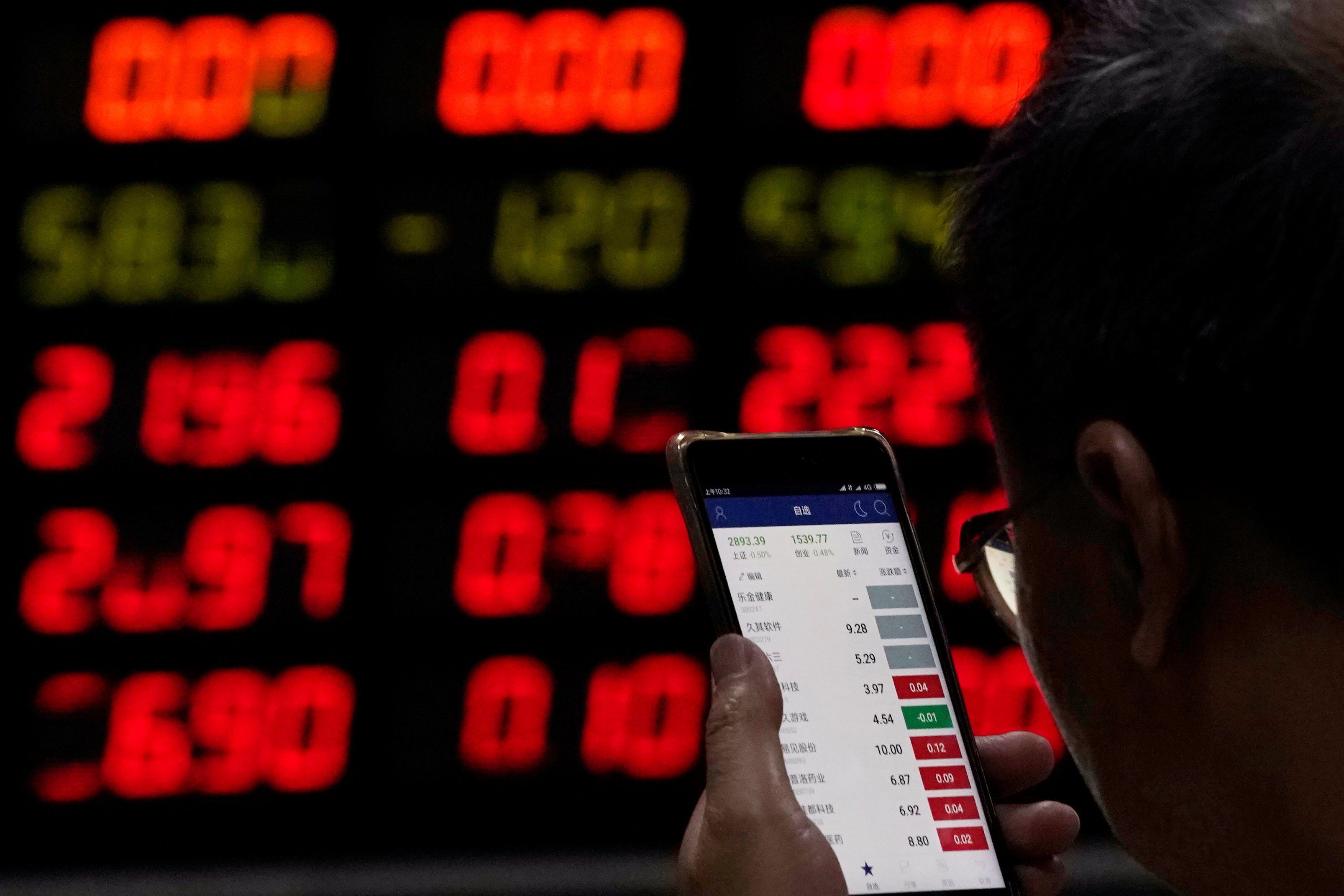 An investor checks stock information on a mobile phone at a brokerage house in Shanghai on June 20, 2018. Photo: Aly Song